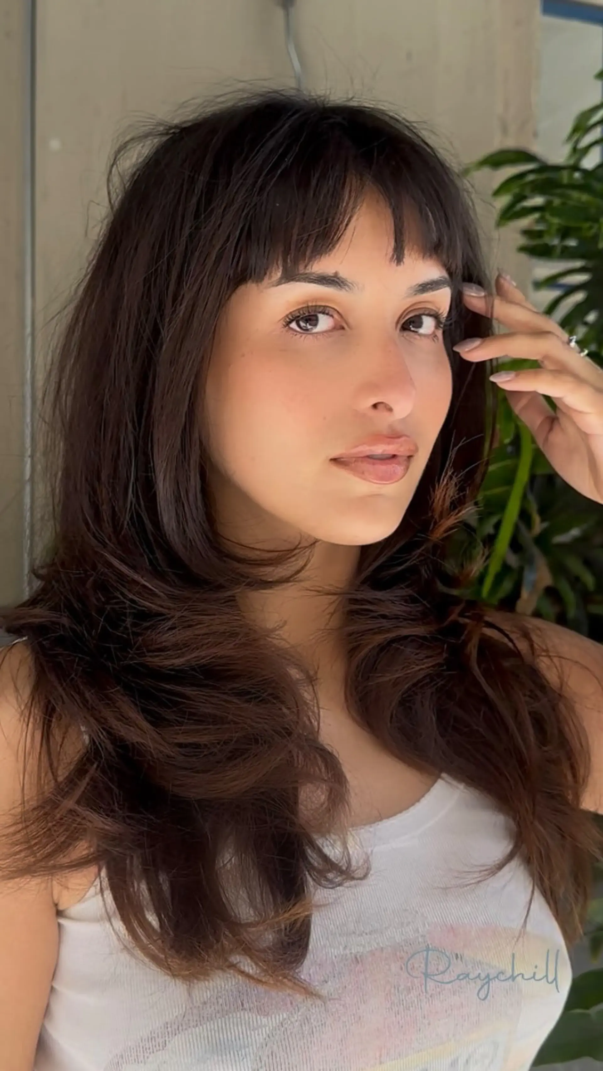 Long dark brown hair cut with soft, textured baby bangs and flowing face-framing layers. 1