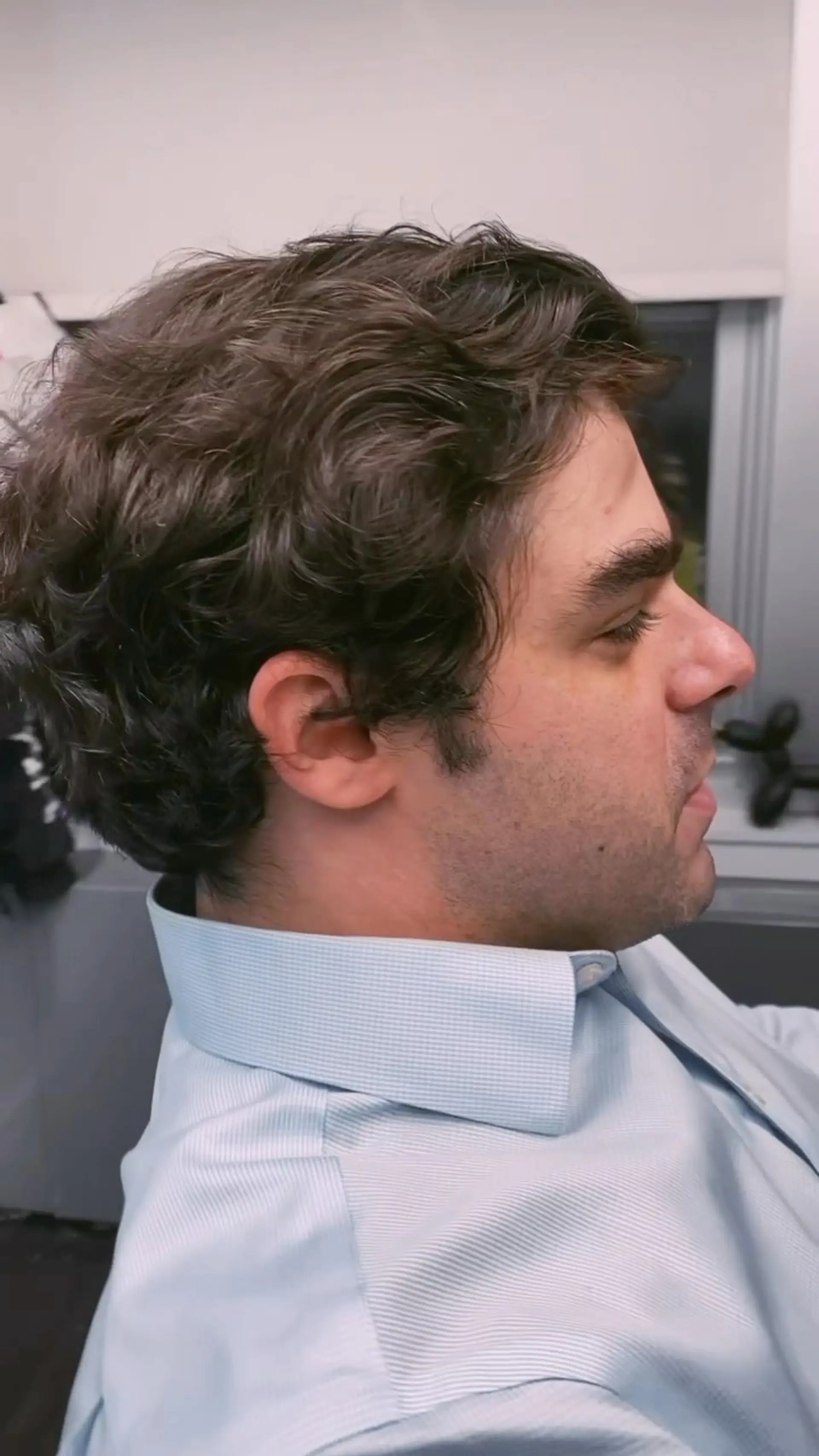 A natural, wavy men's haircut with soft layering and clean tapering around the neckline and ears. 1