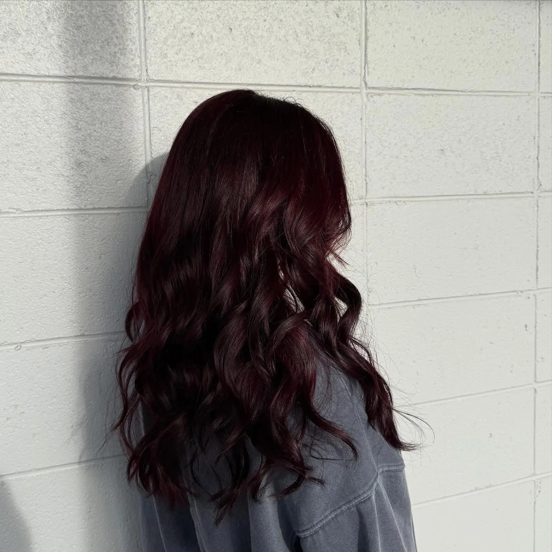 Rich, glossy cherry cola burgundy hair with soft, loose waves cascading down the back. 1