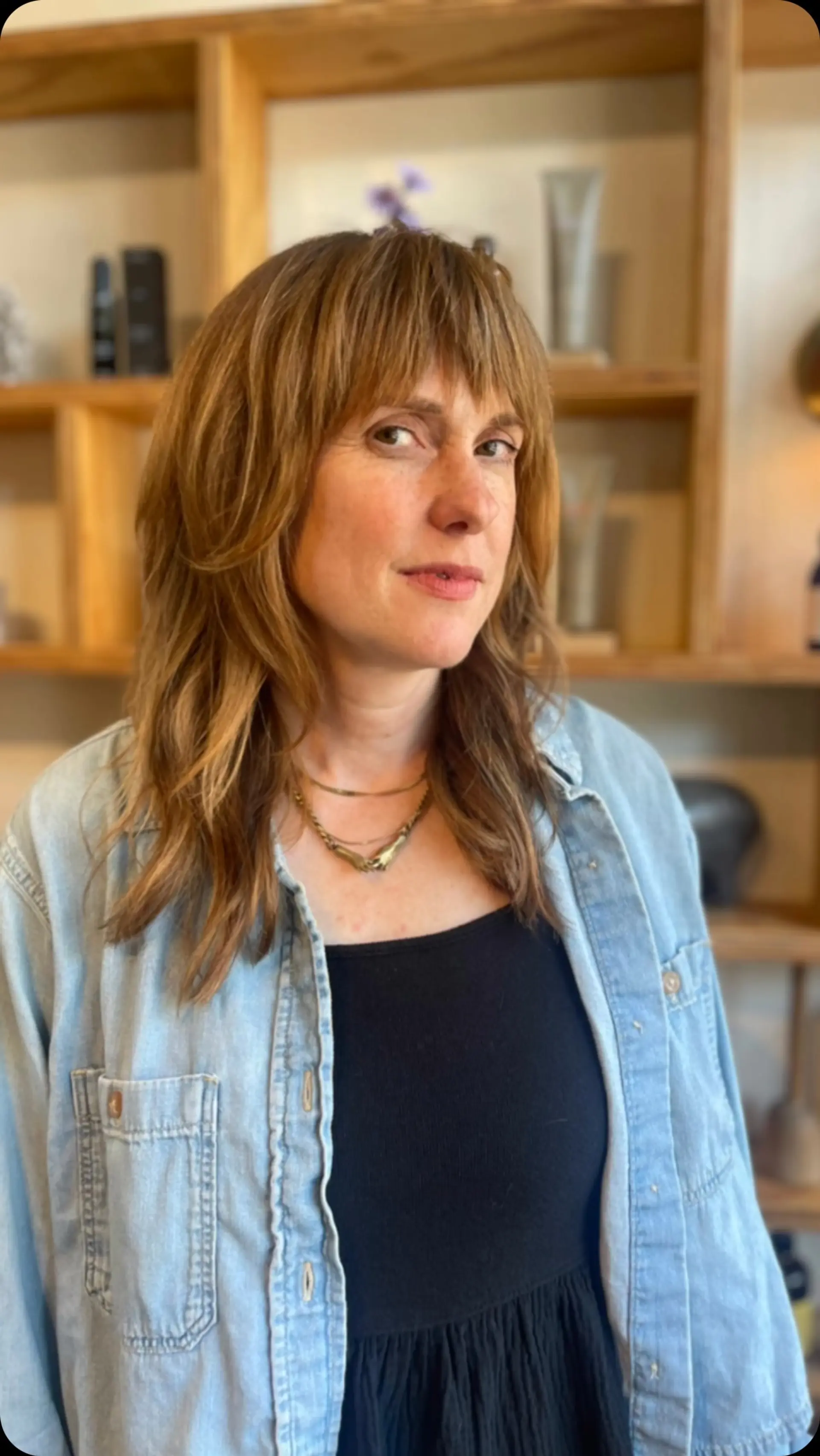 Medium-length layered shag with full bangs and subtle golden balayage. 1