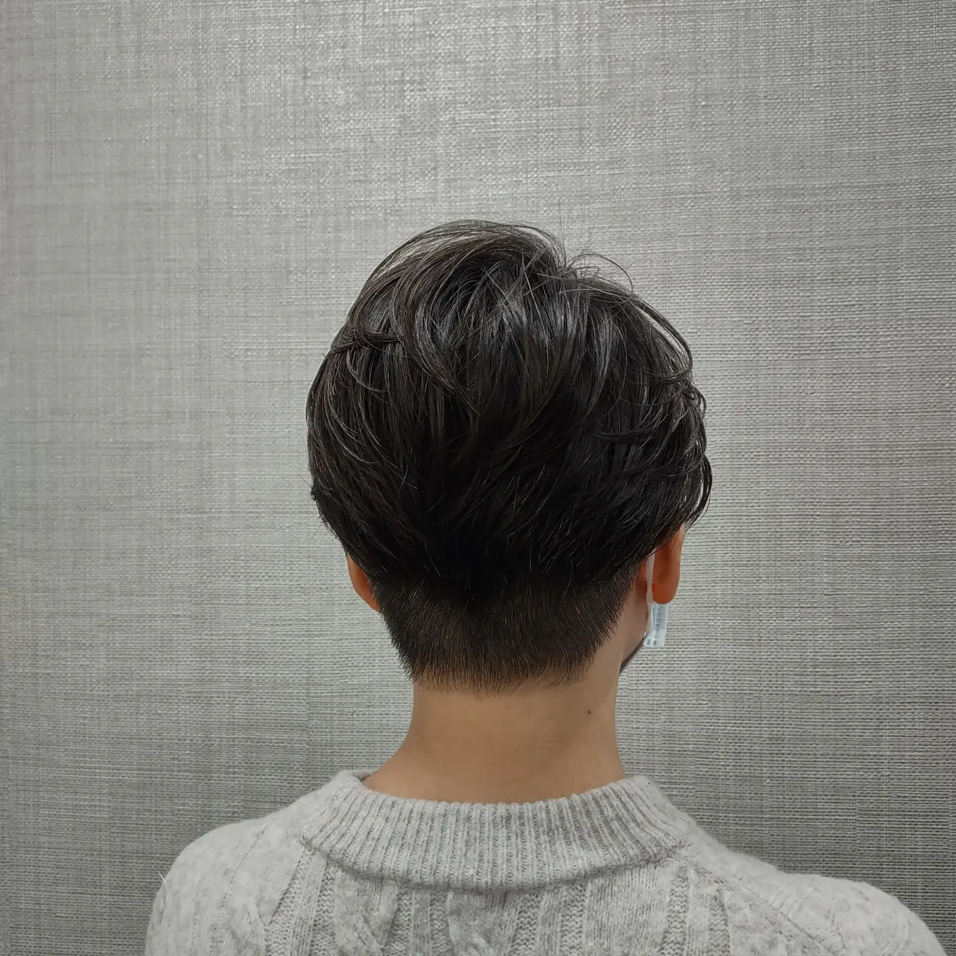 A modern short pixie cut with a clean, tapered undercut at the nape and textured, layered volume across the crown. 1