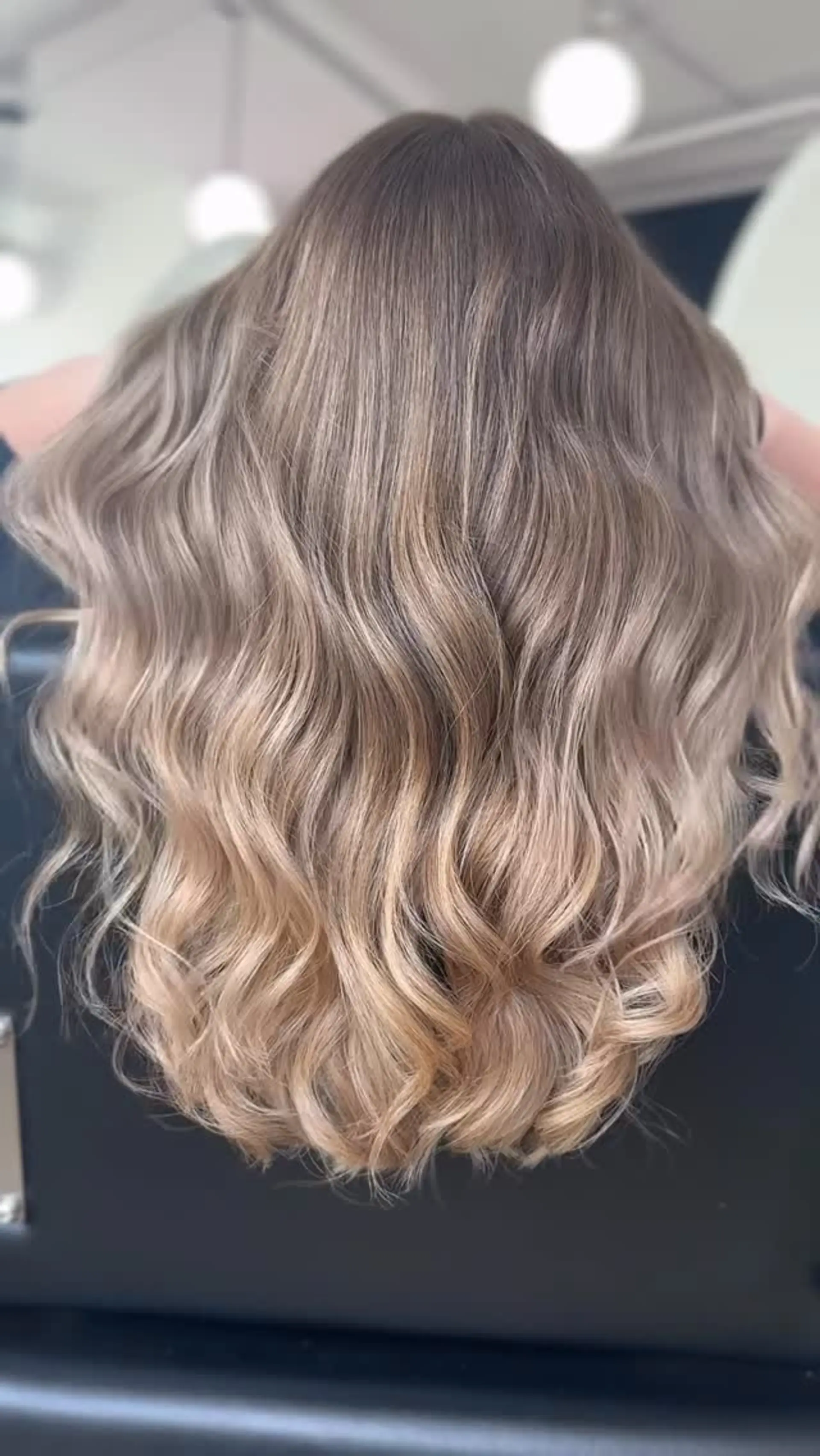 Medium-length dimensional honey blonde hair styled with soft, loose waves. 1