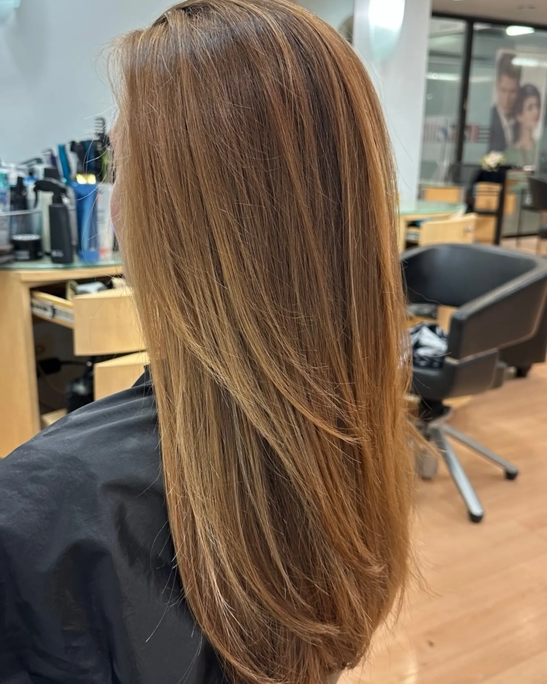 Sleek long hair with soft face-framing layers and dimensional warm blonde highlights. 1