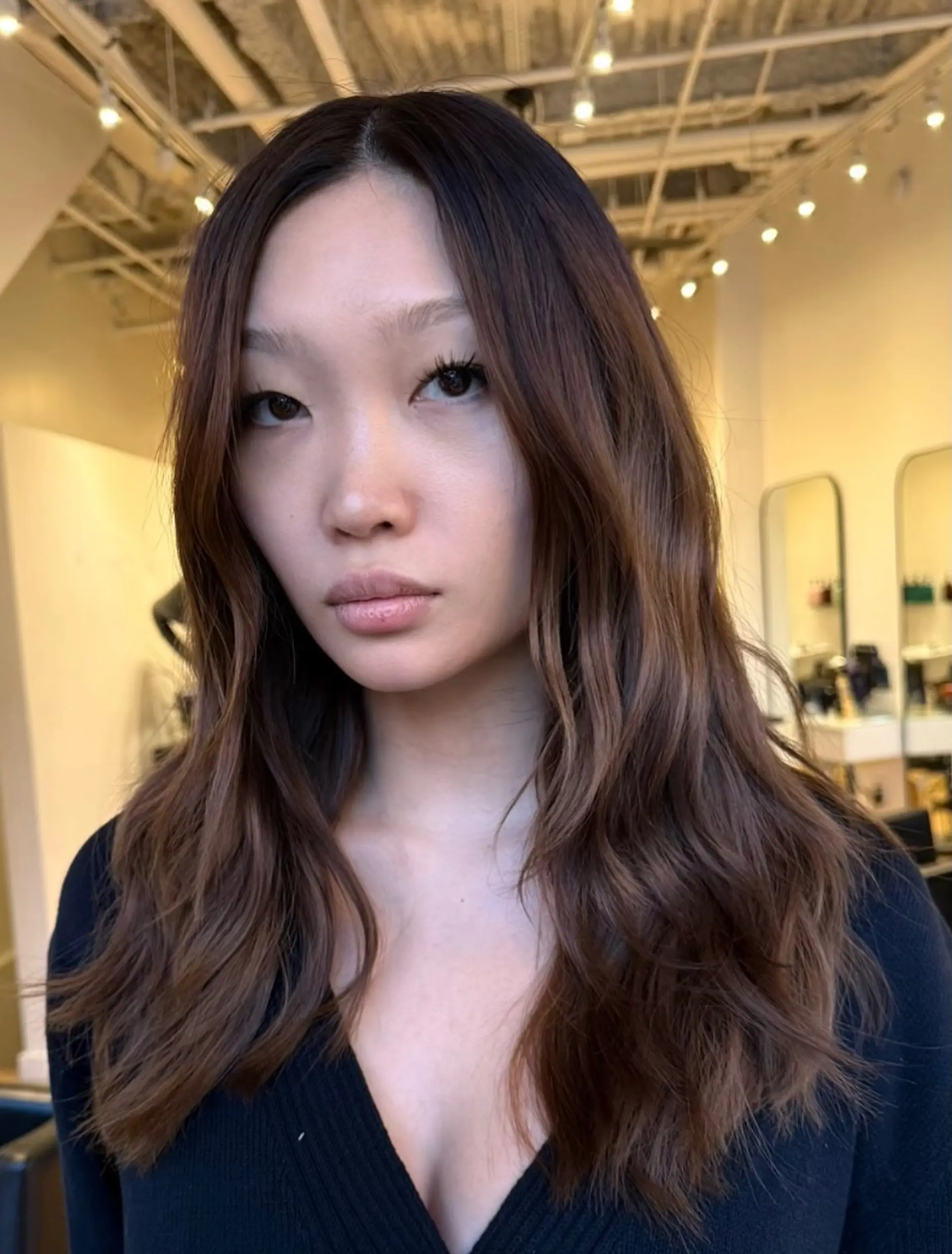 Long chocolate brown hair styled in soft, subtle waves with a clean middle part and seamless color blending. 1