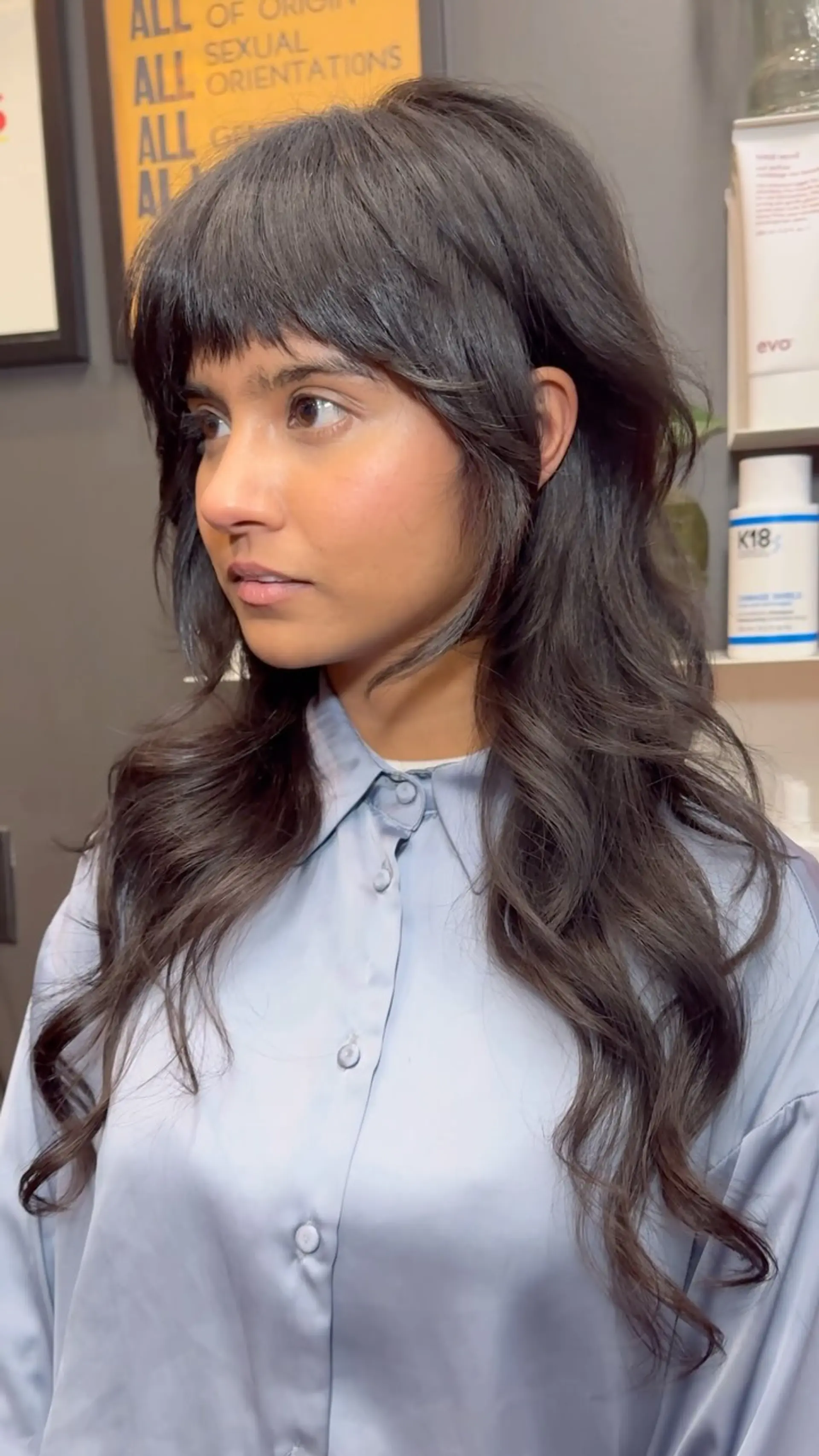A textured long shag haircut with choppy, brow-grazing bangs and heavily layered face-framing pieces tapering into soft waves. 1