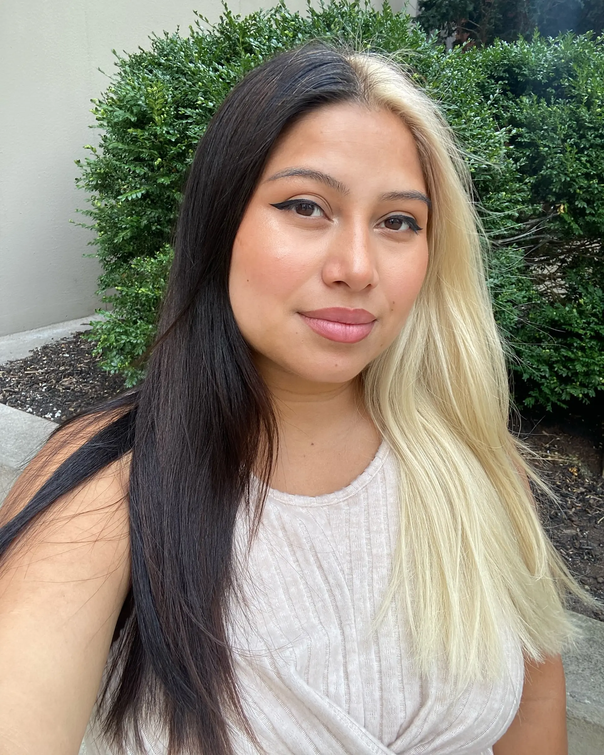 A bold split-dye look parted down the middle, featuring jet black on one side and cool platinum blonde on the other. 1