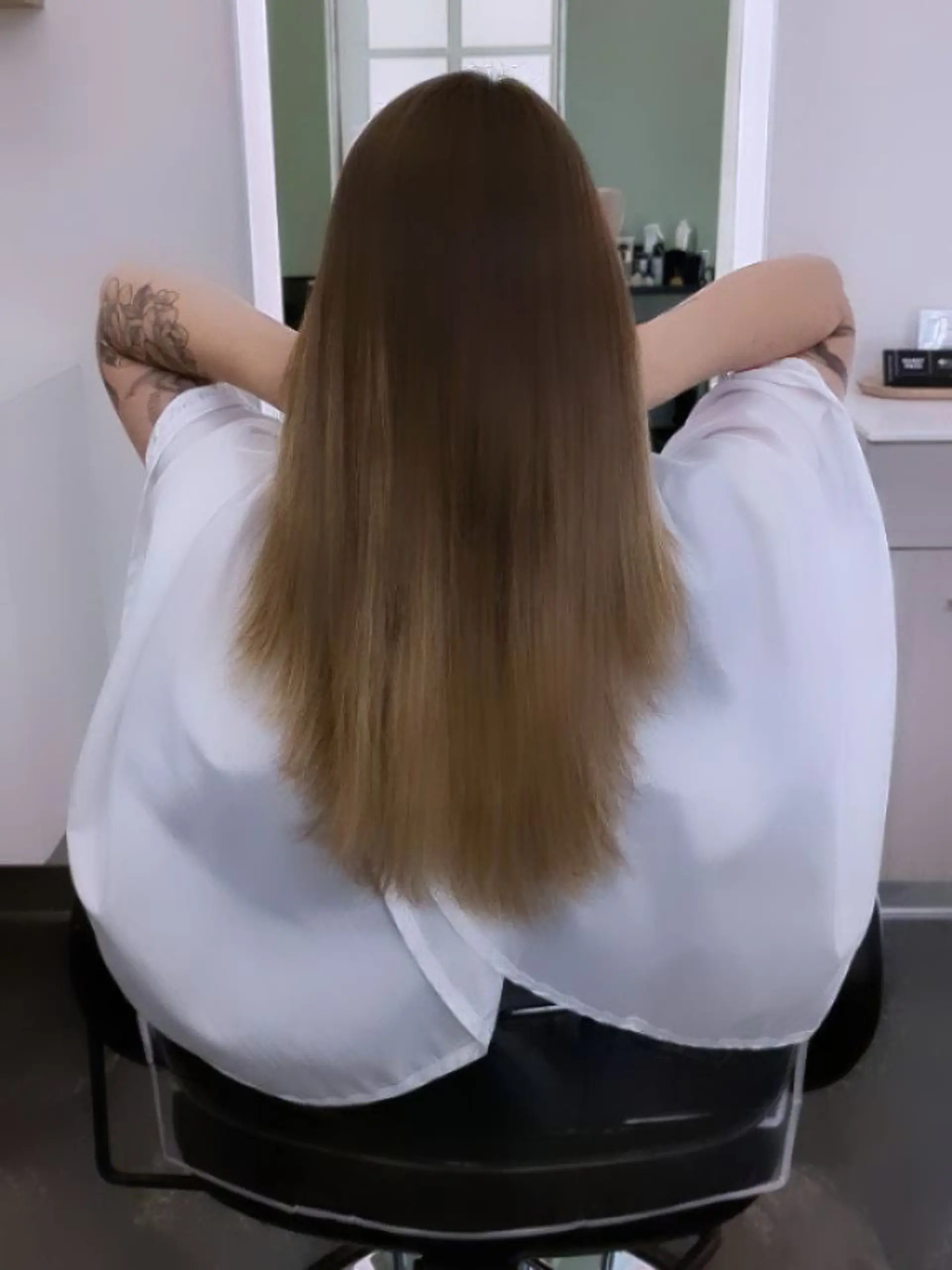 Silky, pin-straight medium-length hair falling smoothly down the back after a Japanese thermal straightening treatment. 1