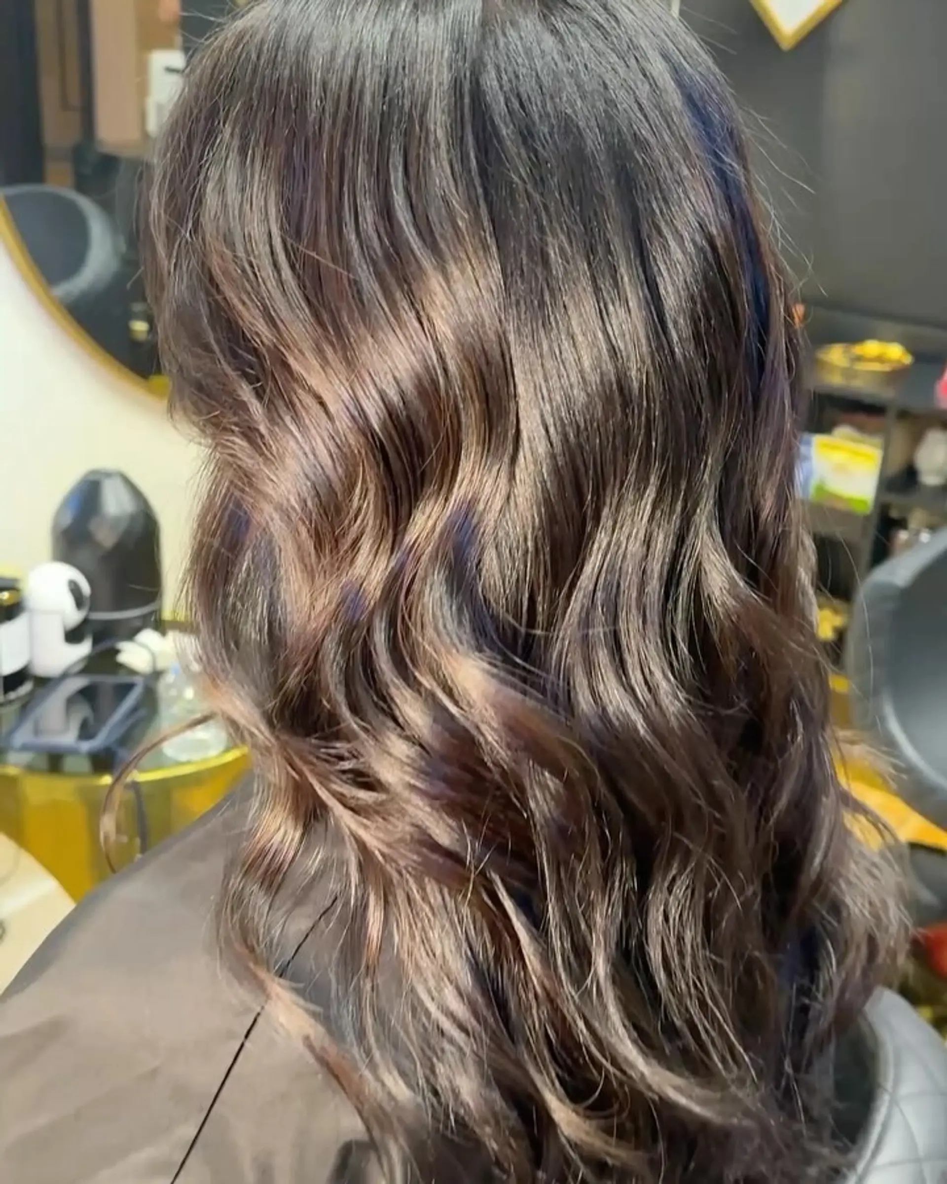 Medium-length dark brunette hair styled in glossy, soft textured waves with subtle multidimensional warm brown tones. 1