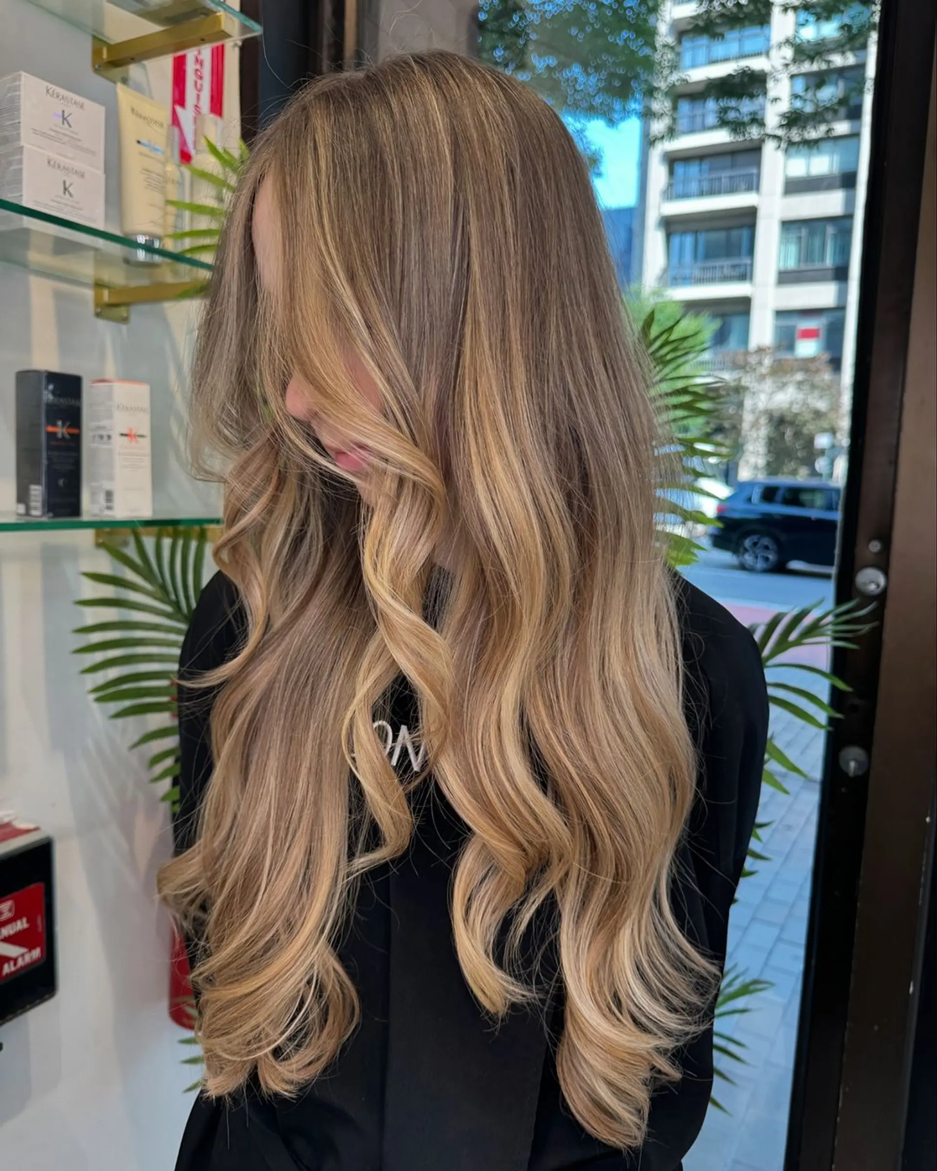 Very long, wavy hair with a blend of dark blonde and golden blonde tones. Soft waves, voluminous, layered, side part, with natural shine. 1