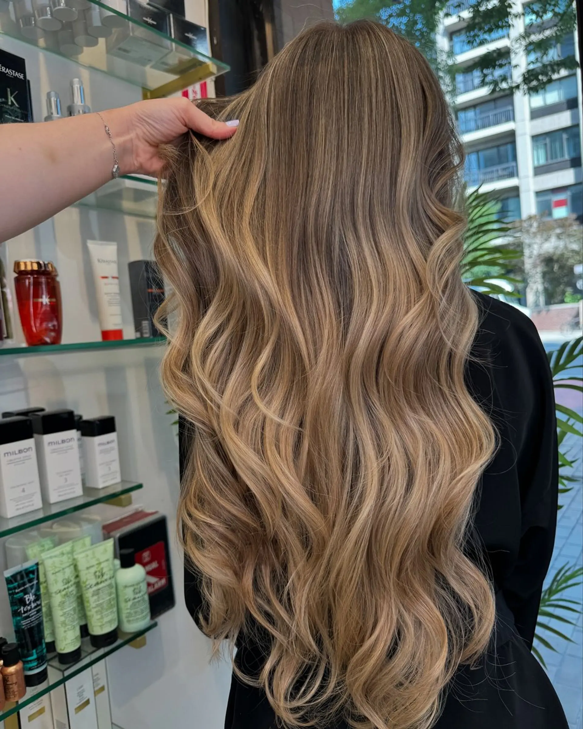 Very long, wavy hair with a blend of dark blonde and golden blonde tones. Soft waves, voluminous, layered, side part, with natural shine. 2