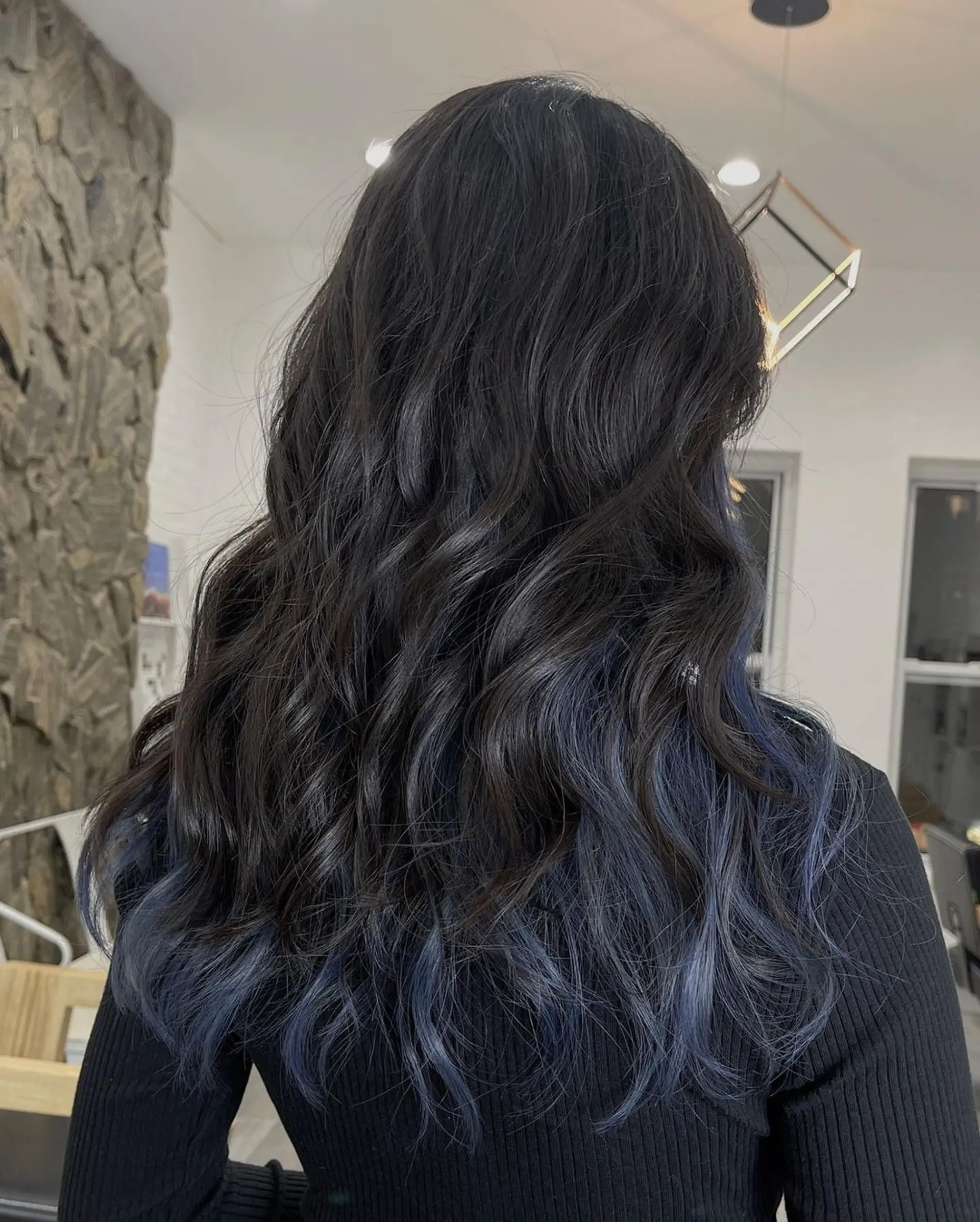 Medium-length, wavy hair with black to blue balayage, face-framing layers, and a stylish, voluminous texture. 3
