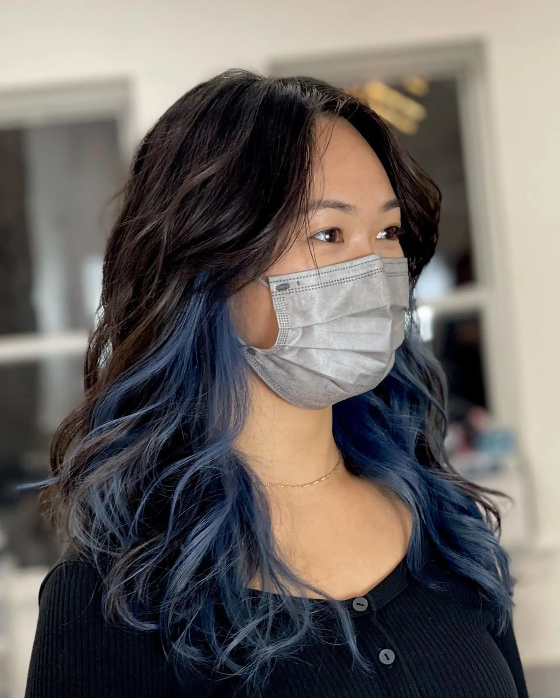 Medium-length, wavy hair with black to blue balayage, face-framing layers, and a stylish, voluminous texture. 4