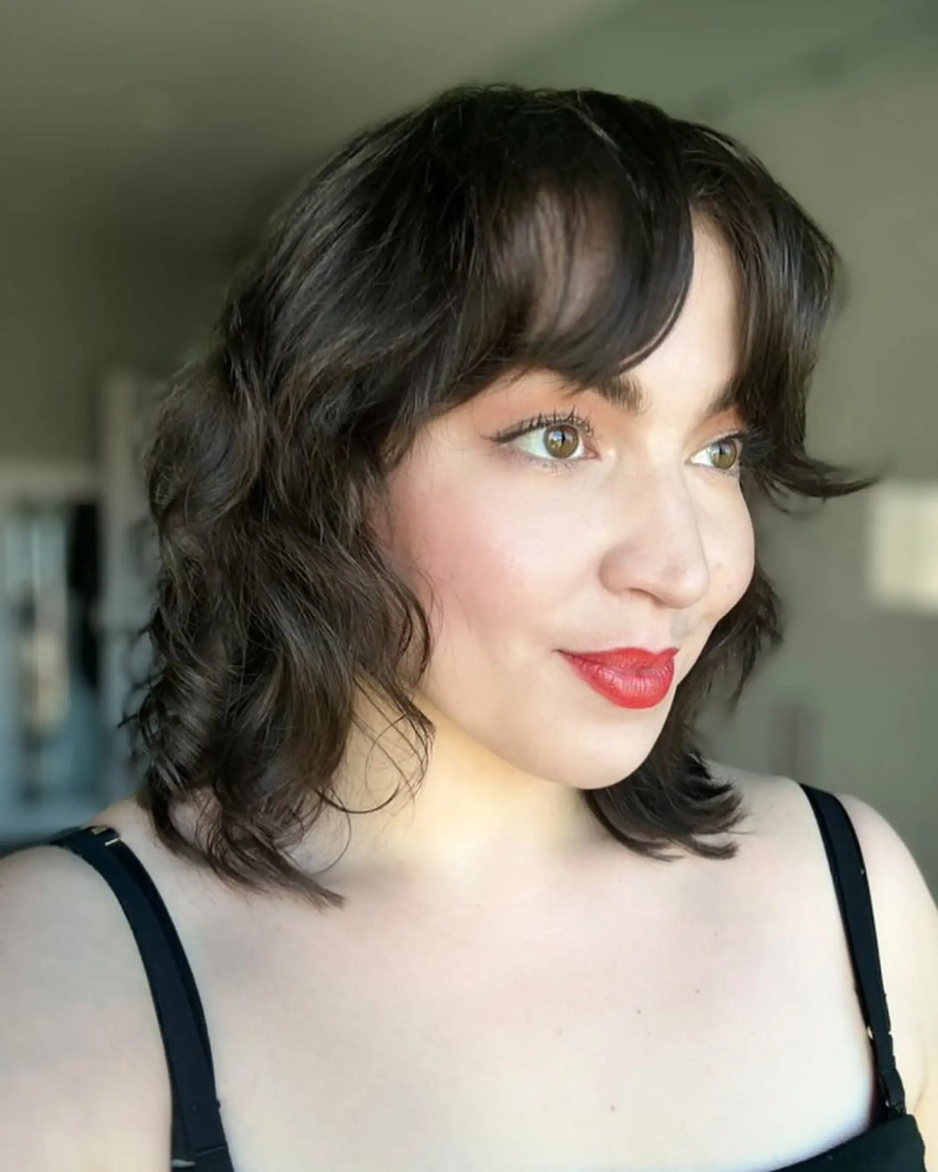 A medium-length shag haircut with textured layers and bangs. 3