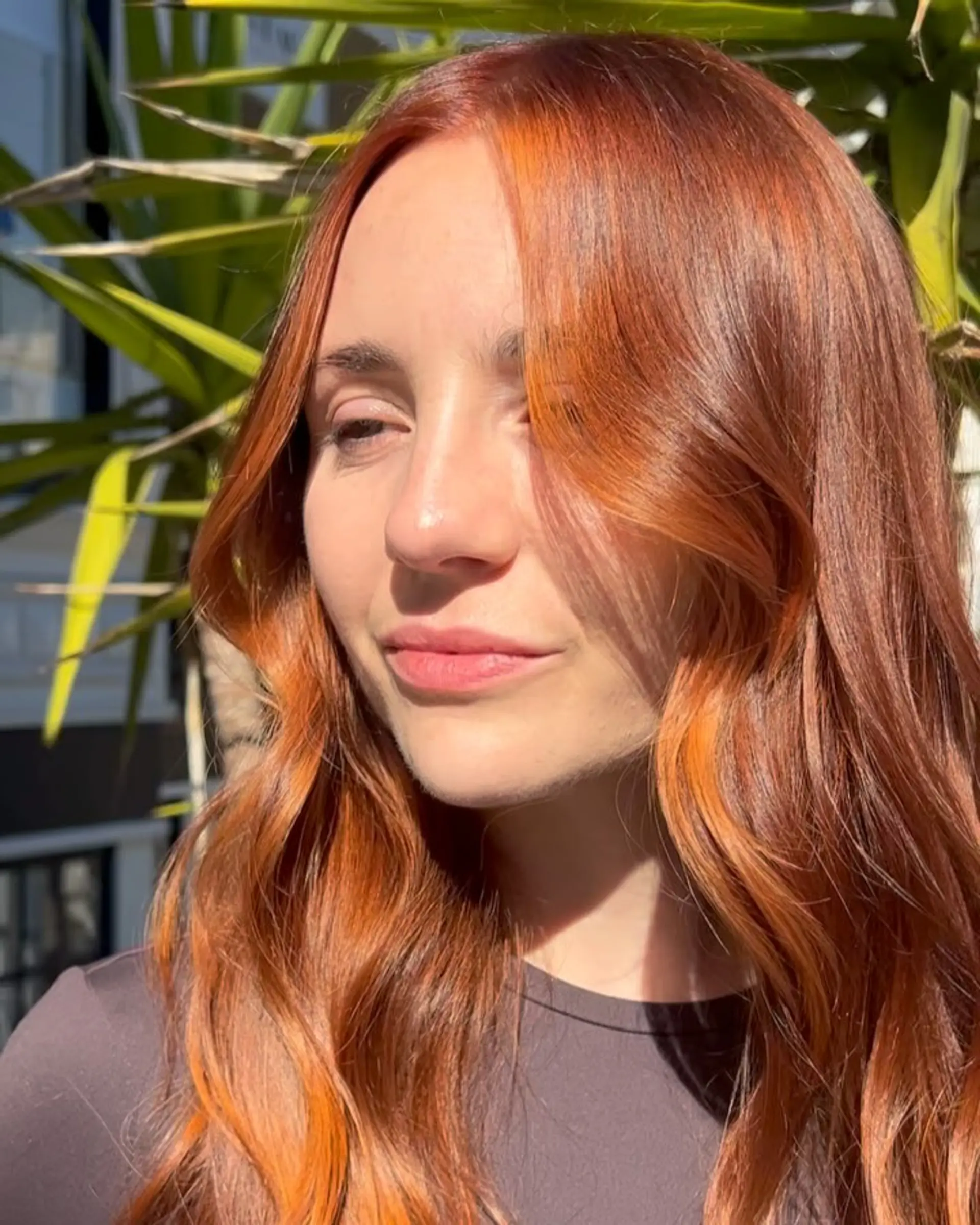 Vibrant dimensional copper hair styled in soft, glossy waves framing the face. 1