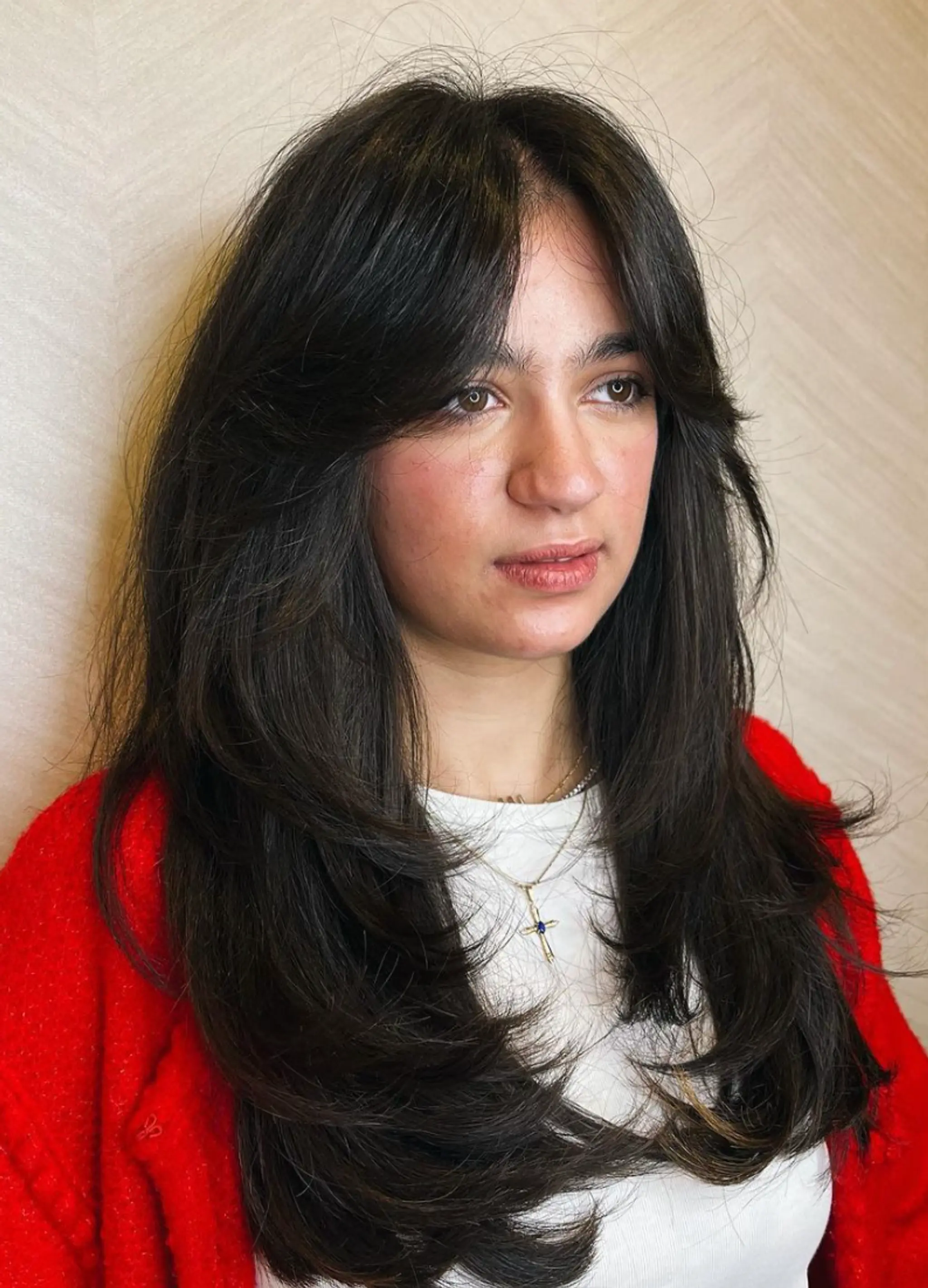 Elegant Layers is a long, dark brown wavy hairstyle featuring curtain bangs, natural volume, and feathered ends for added movement and lightness.

Cut and style by @juliamannino_hair
