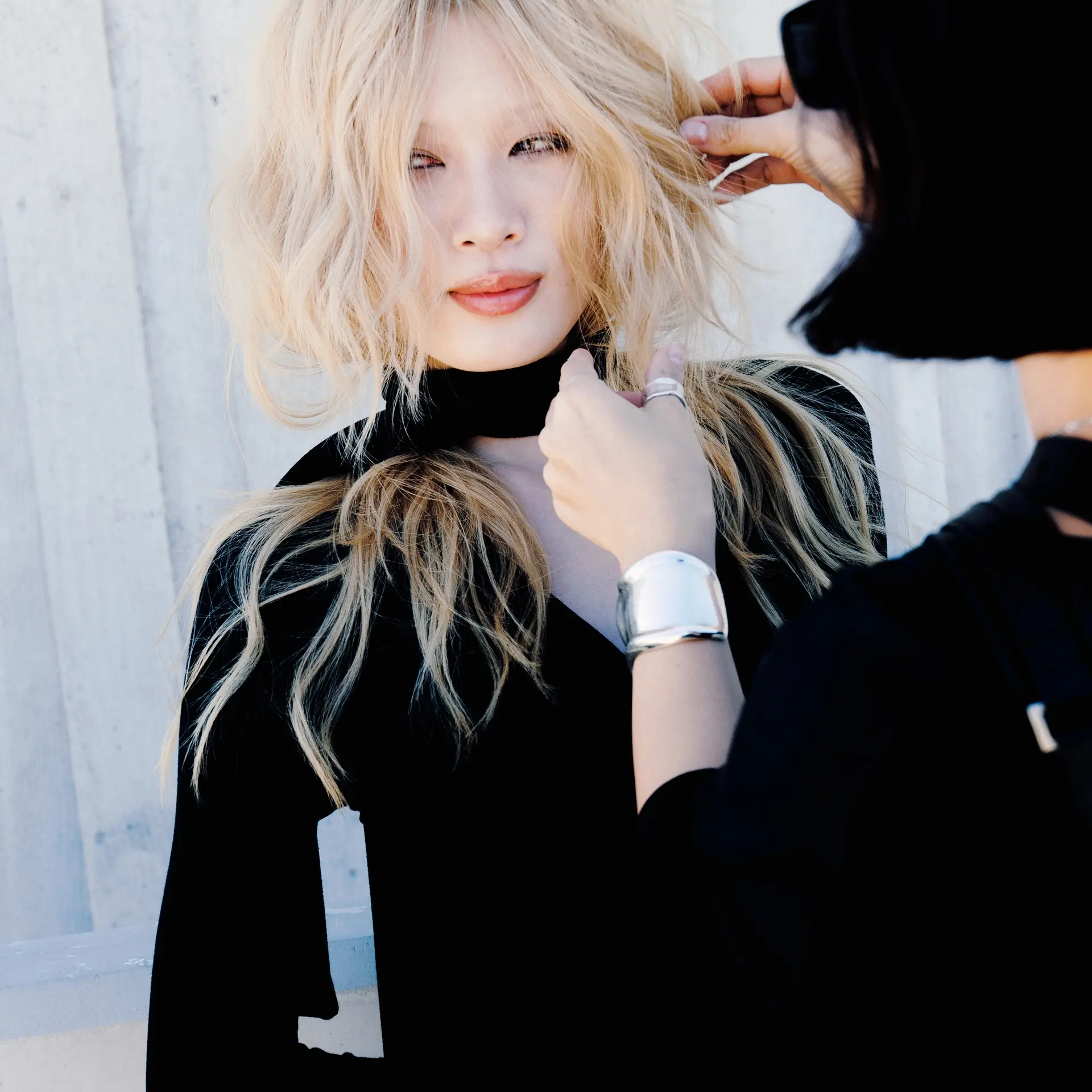 A textured medium-length shag haircut in pale platinum blonde featuring tousled waves and wispy layers. 1