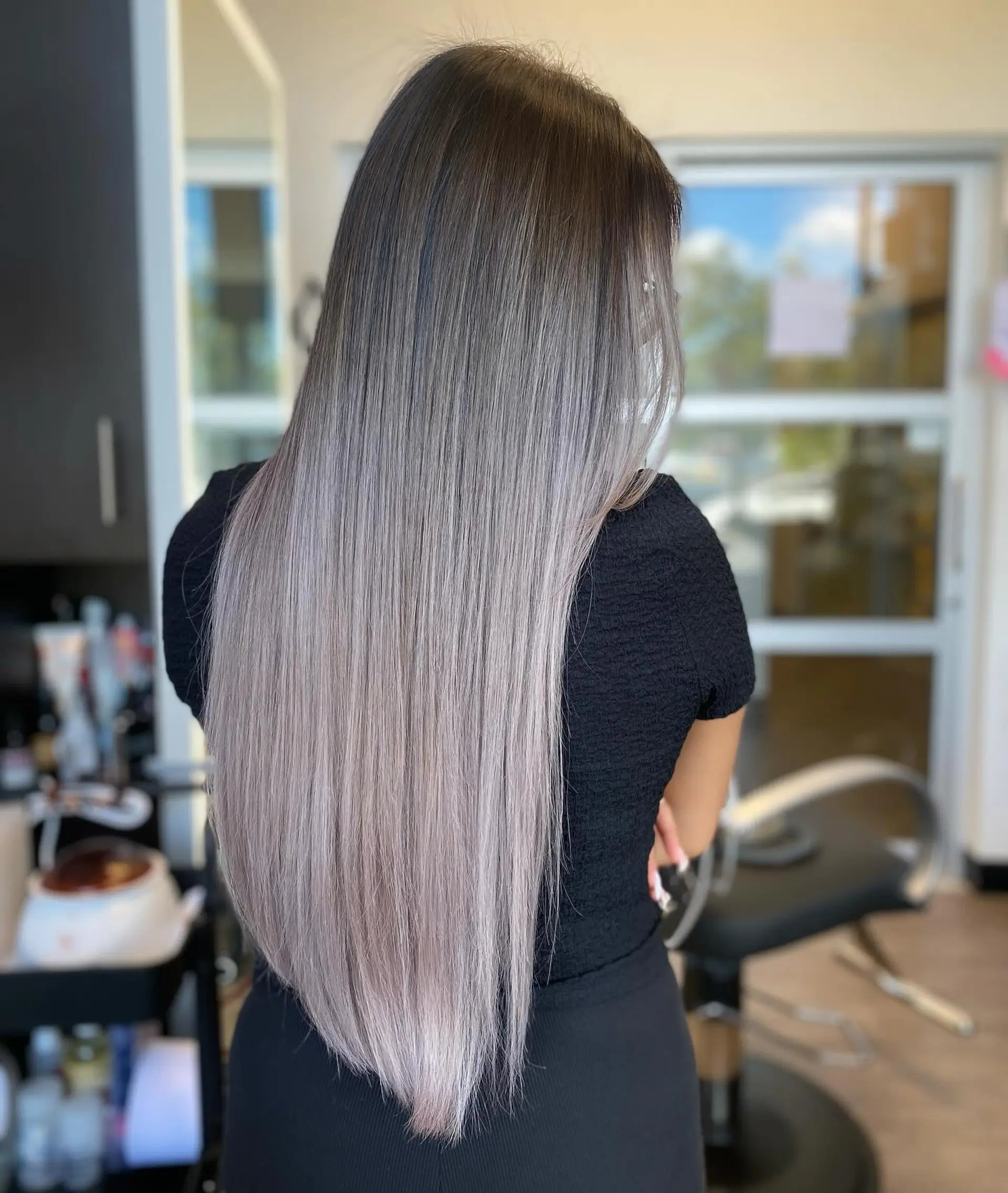 Extra-long sleek straight hair featuring an airtouch color melt from deep cool brown roots into a cool-toned ash blonde. 1