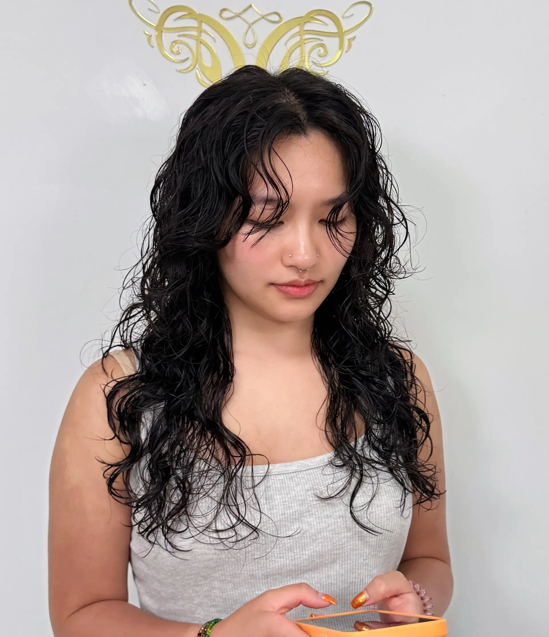 A stylish, long, layered cut that emphasizes the natural curl pattern and provides a glamorous wet look. 1