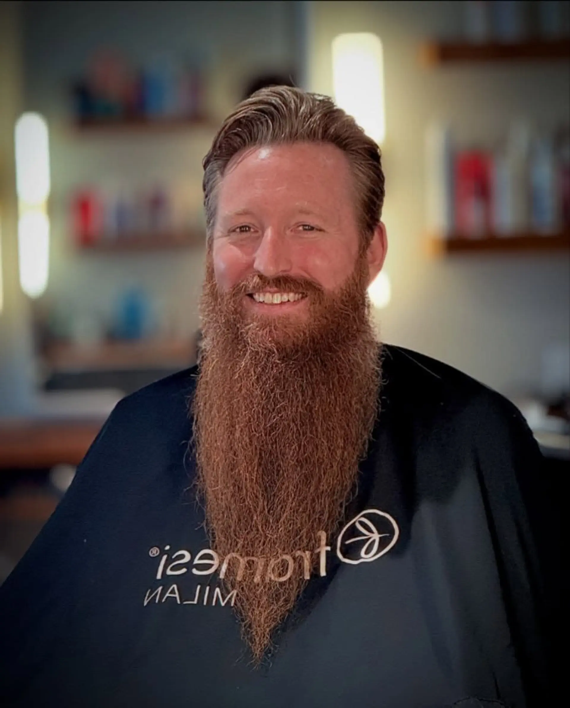 A men's brushed-back haircut paired with a long, meticulously groomed full beard tapered into a sharp point. 1