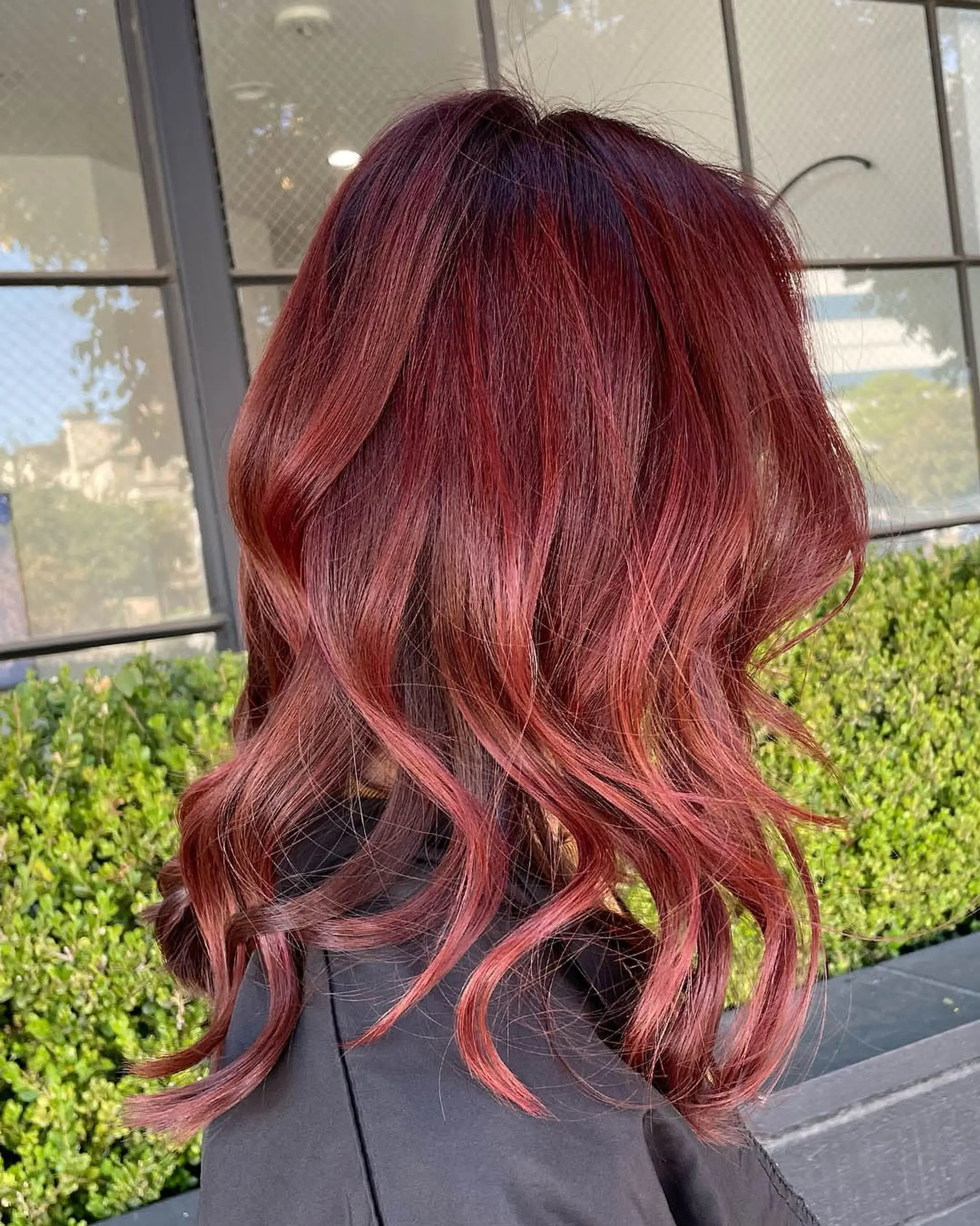 Shoulder-length hair styled in loose textured waves, featuring vibrant cherry red highlights over a deep red-brown base. 1