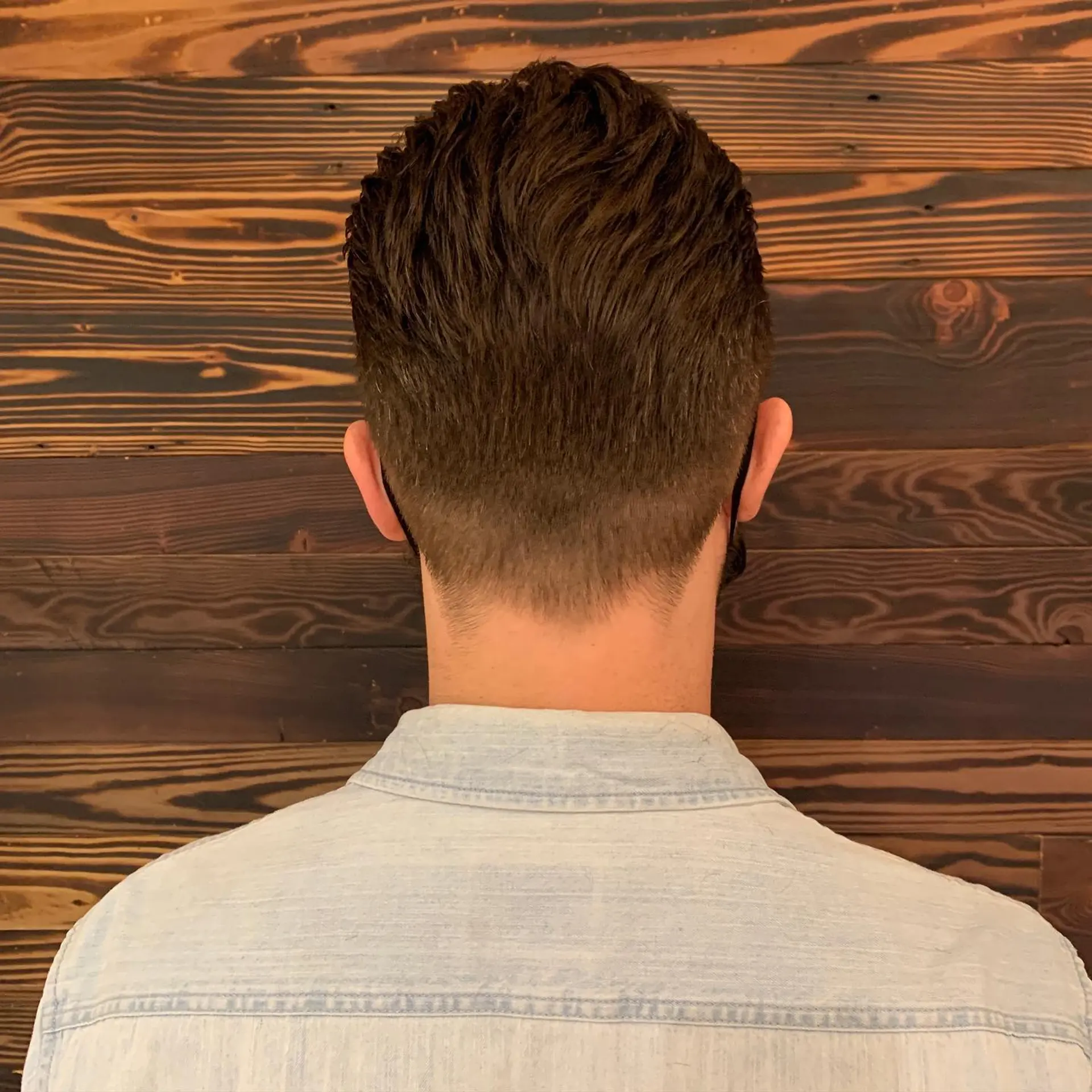 A classic taper fade haircut with a clean, modern look and textured top. 1