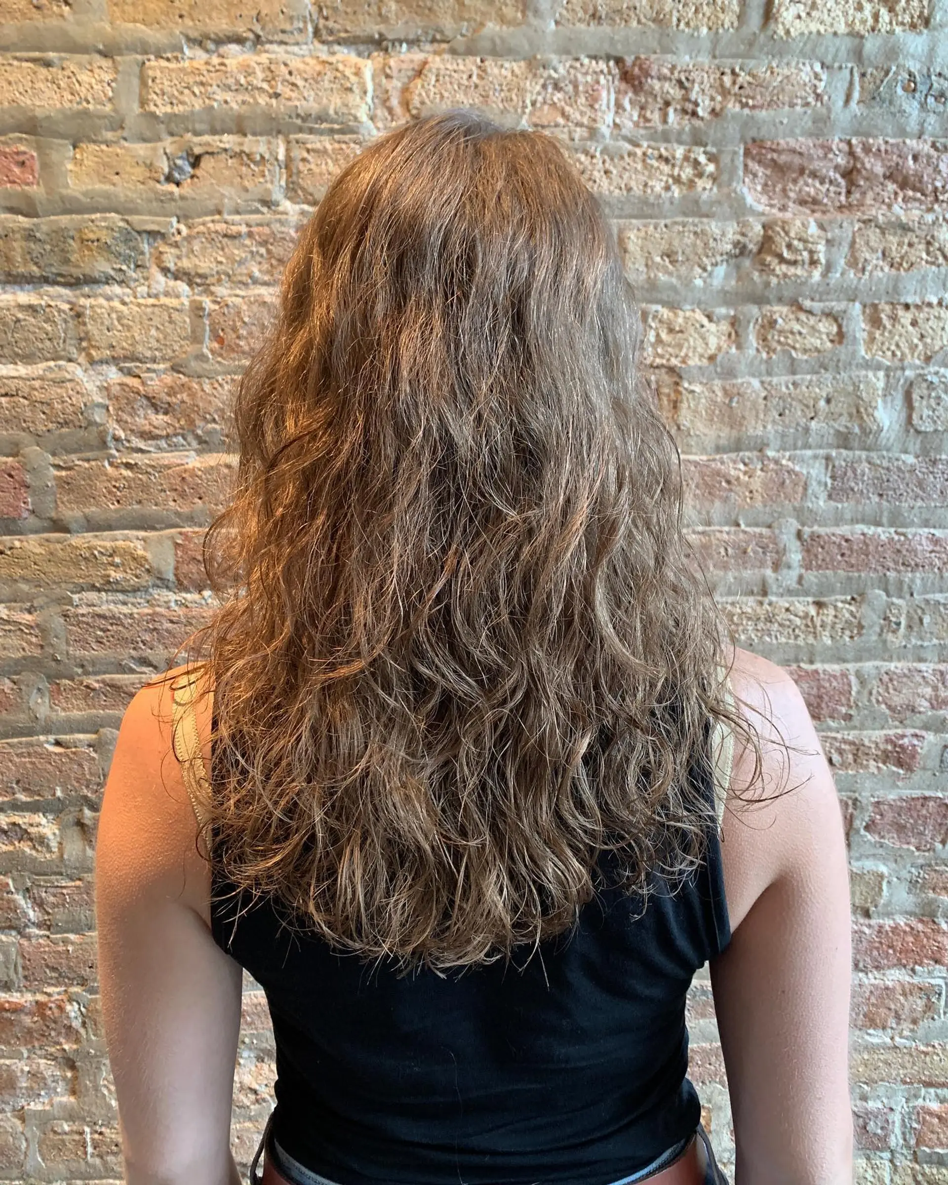 A long, layered wavy hairstyle with a natural, beachy wave texture. 1
