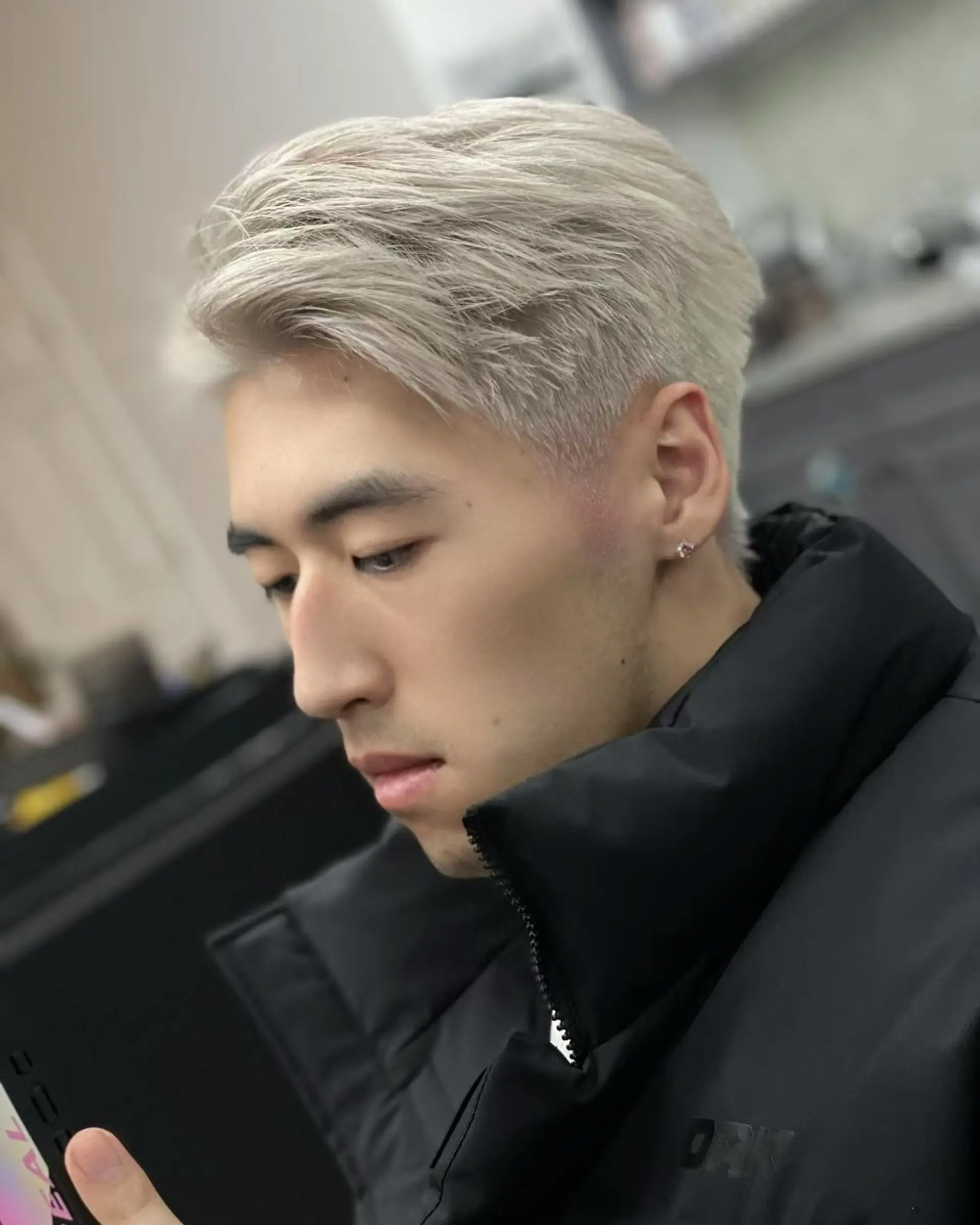 A stylish short haircut with a textured top and faded sides, colored in icy platinum blonde. 1