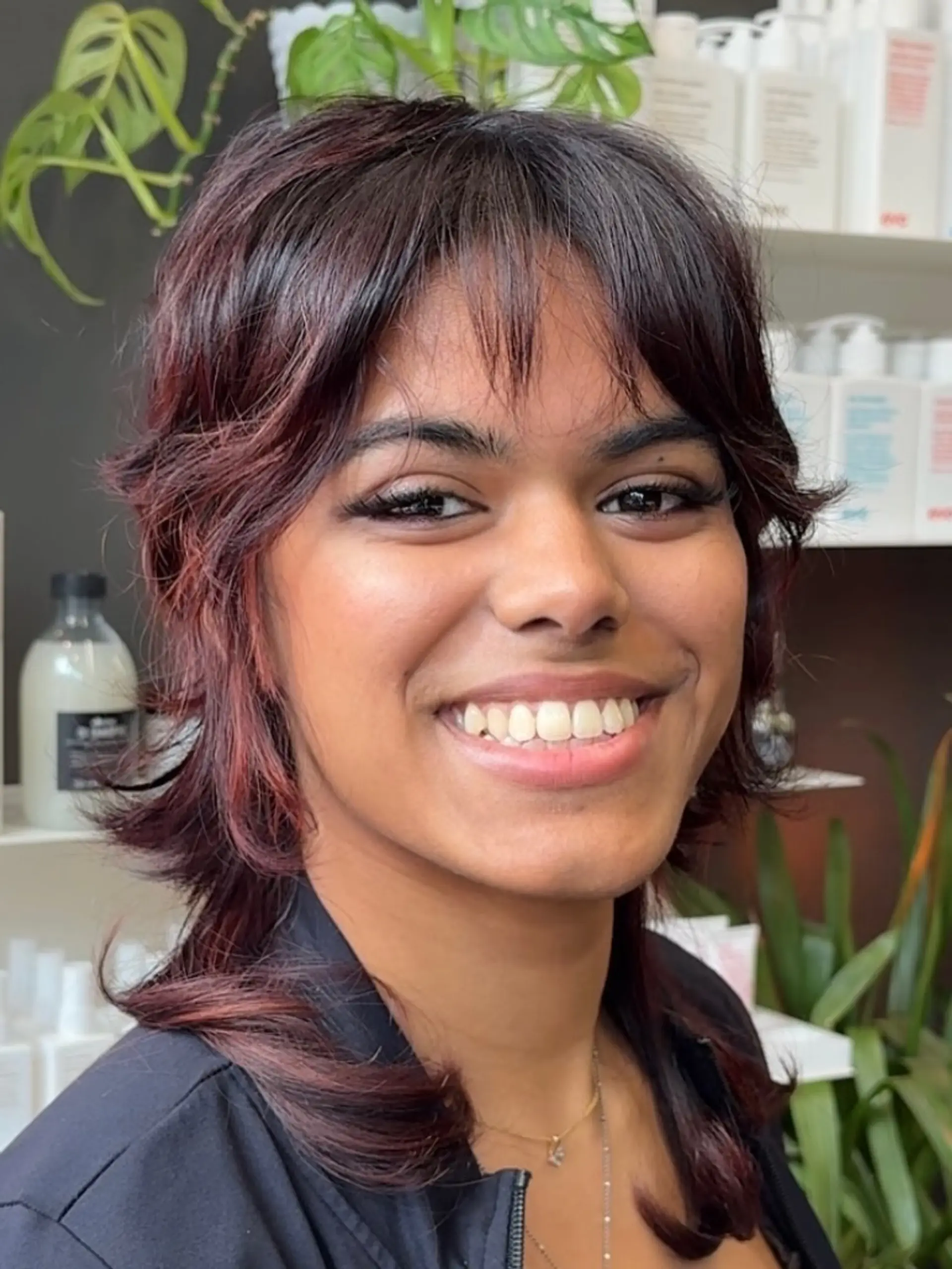 A textured layered jellyfish shag haircut featuring wispy front bangs and reddish-auburn undertones. 1