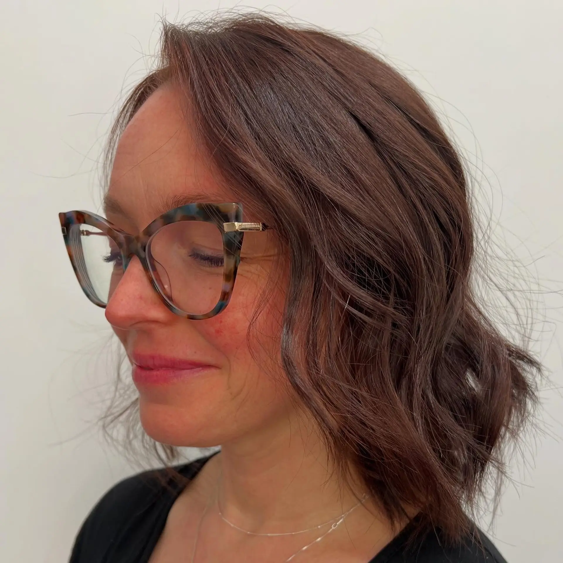 A collarbone-grazing lob haircut styled with effortless, textured waves in a warm chocolate brunette tone. 1