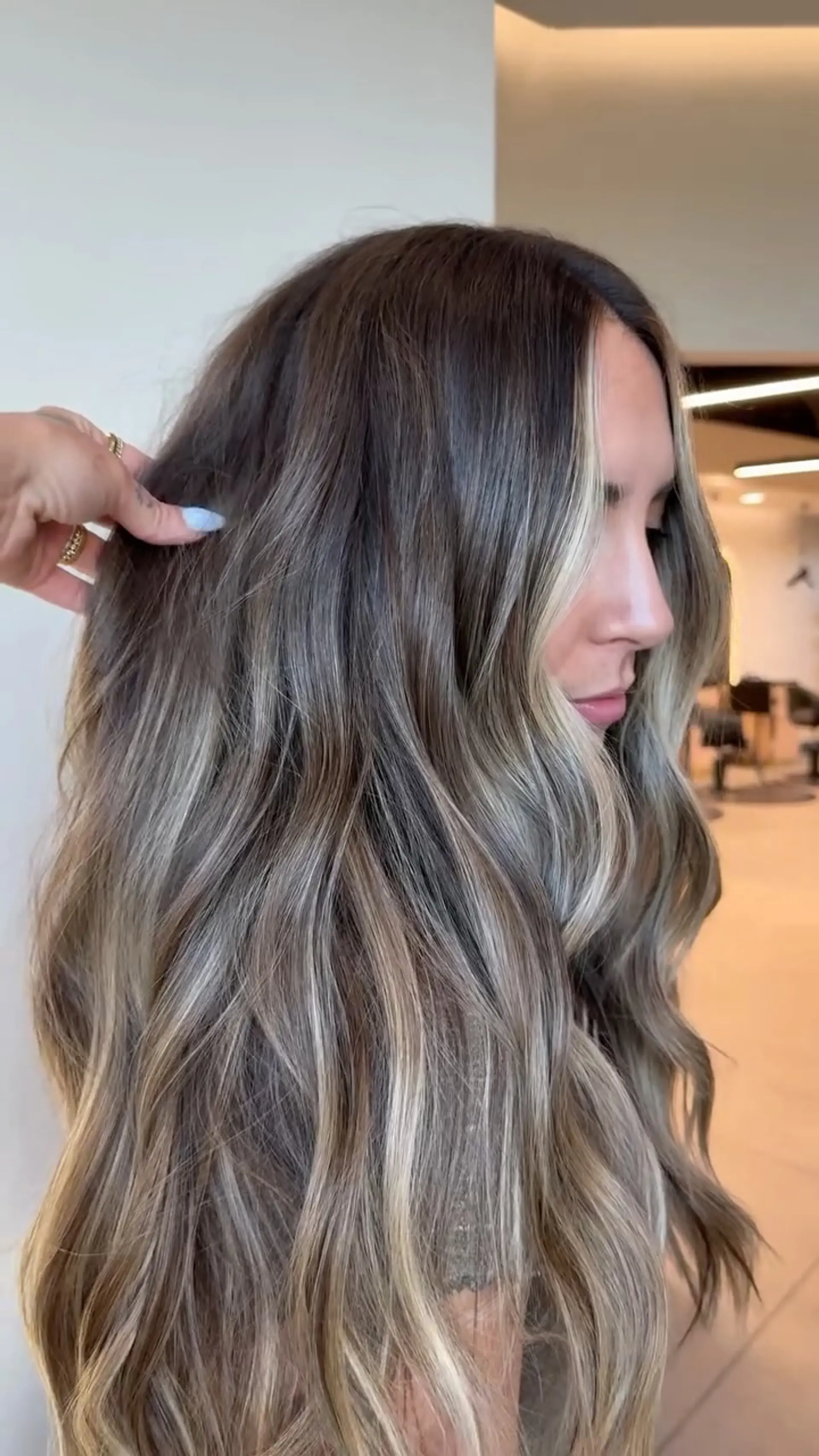 Long dimensional bronde hair styled in loose waves with bright blonde face-framing highlights. 1