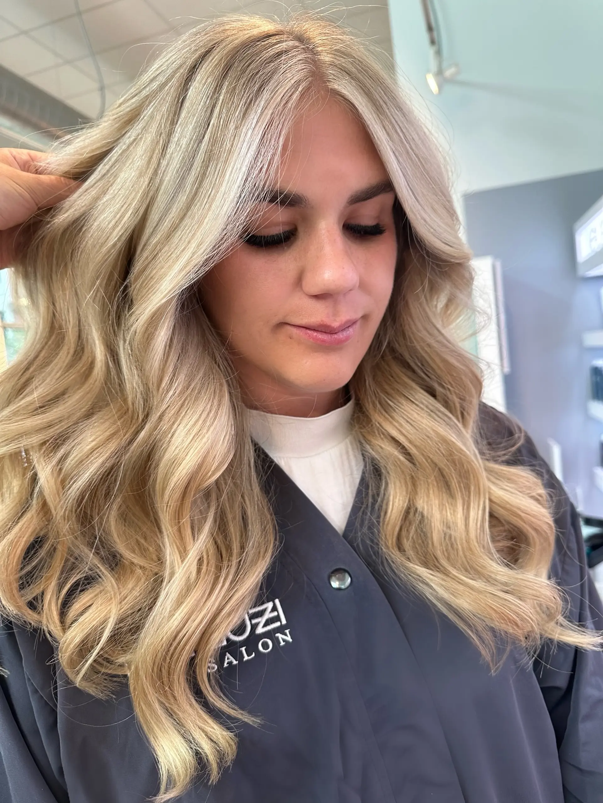 A long wavy hairstyle with a seamless balayage, creating a sun-kissed blonde look. 4