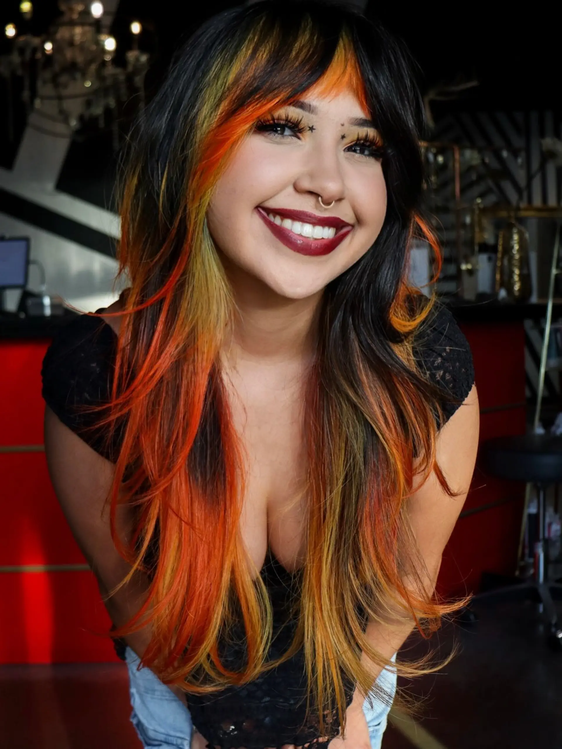 Long layered dark hair featuring vibrant fiery orange and yellow color-blocked panels and bangs. 1