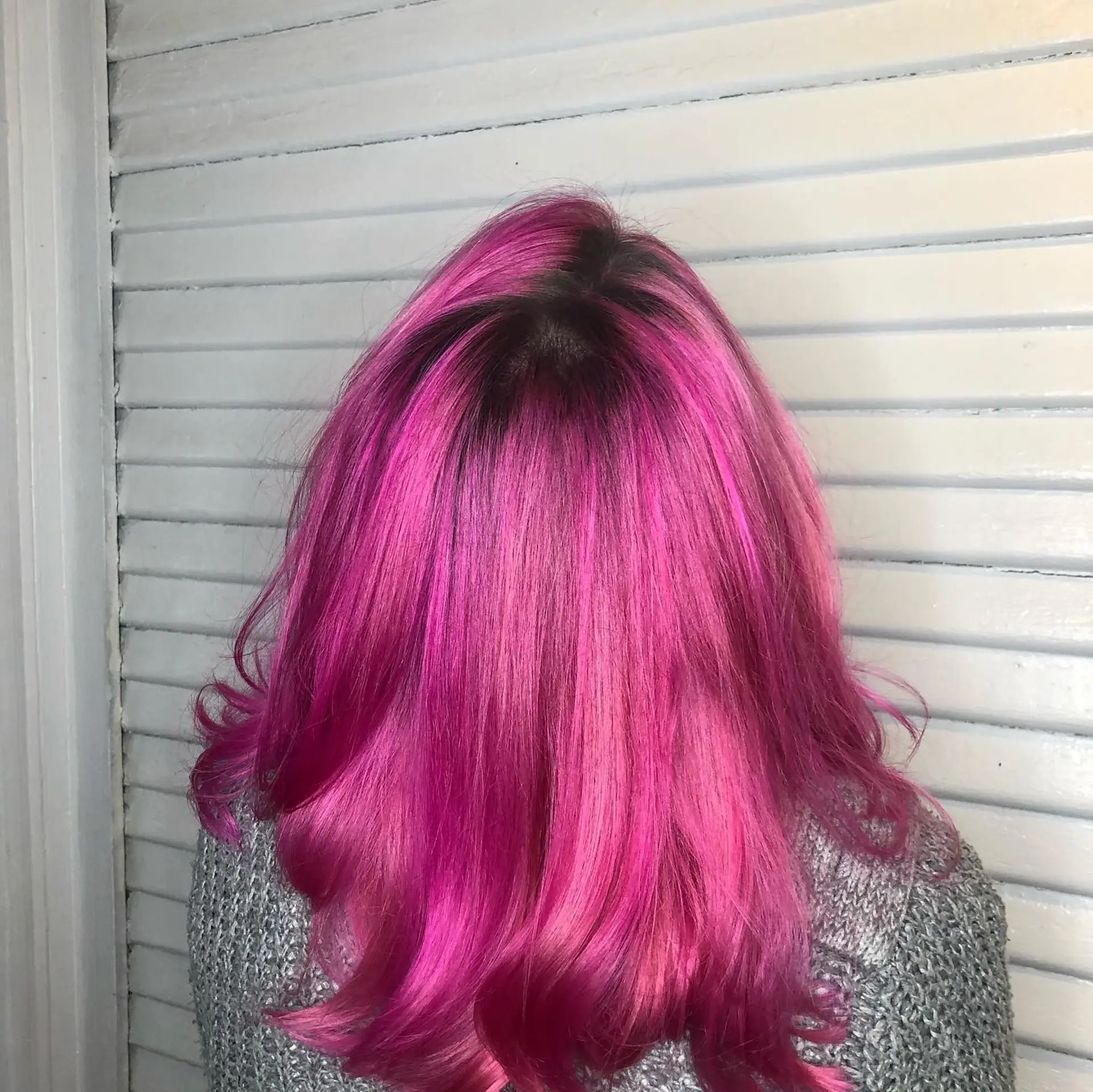 Medium-length vibrant magenta and hot pink hair styled smooth with softly curled ends and a blended dark shadow root. 1
