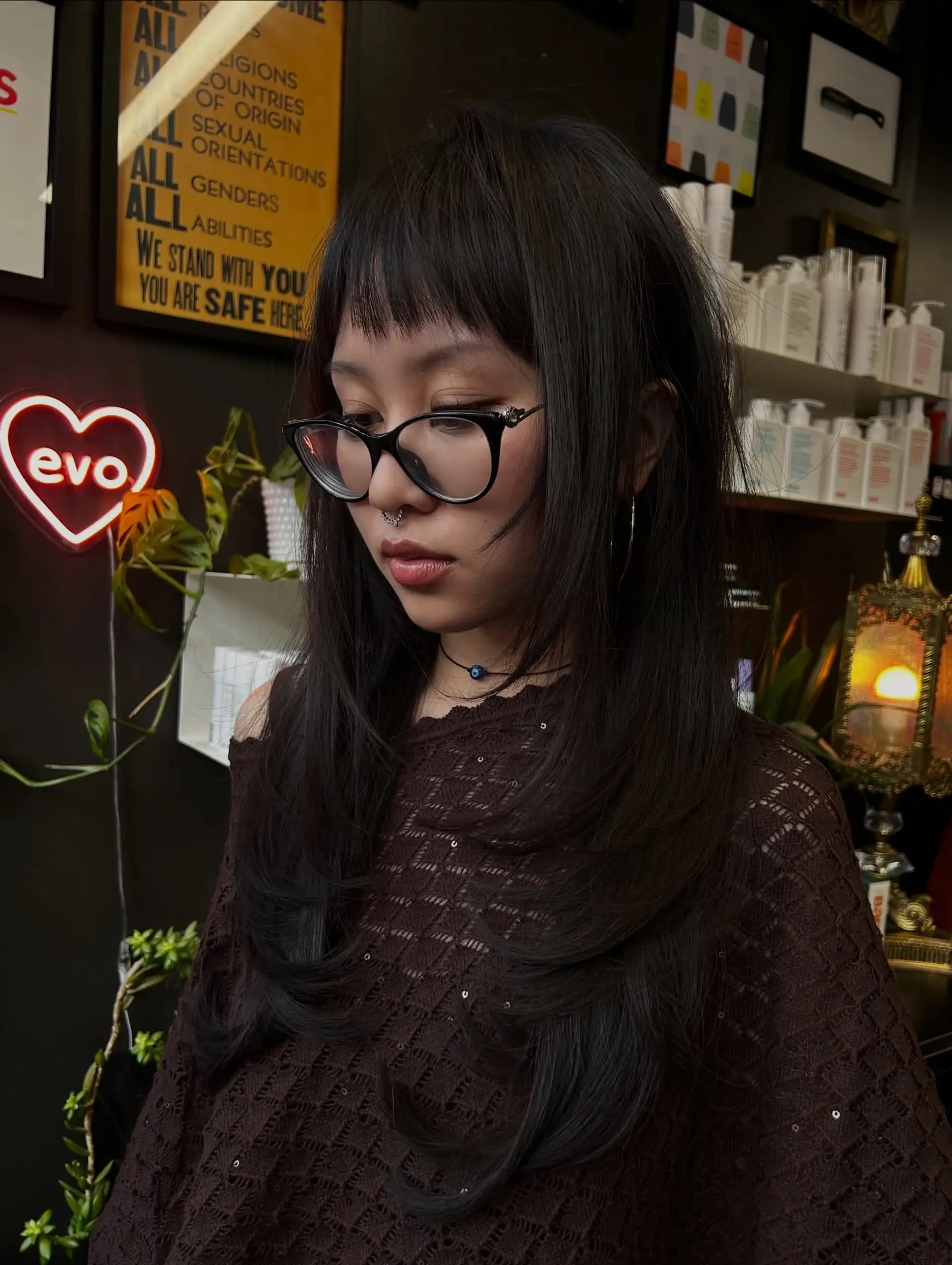 A long, jet-black haircut featuring heavy face-framing layers, soft inward-curled ends, and textured micro bangs. 1