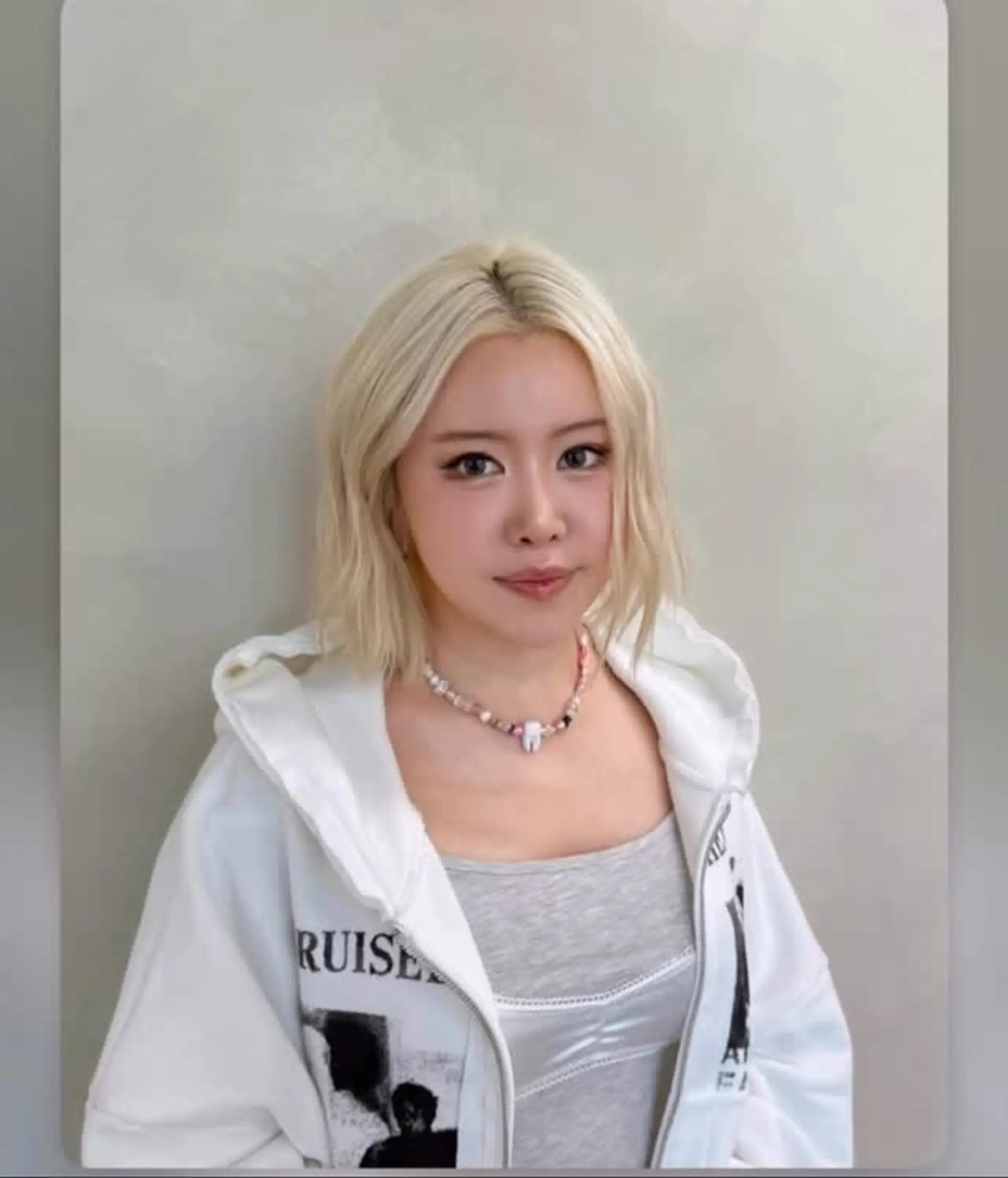 A sleek platinum blonde lob styled with gentle, textured waves and a center part framing the face. 1