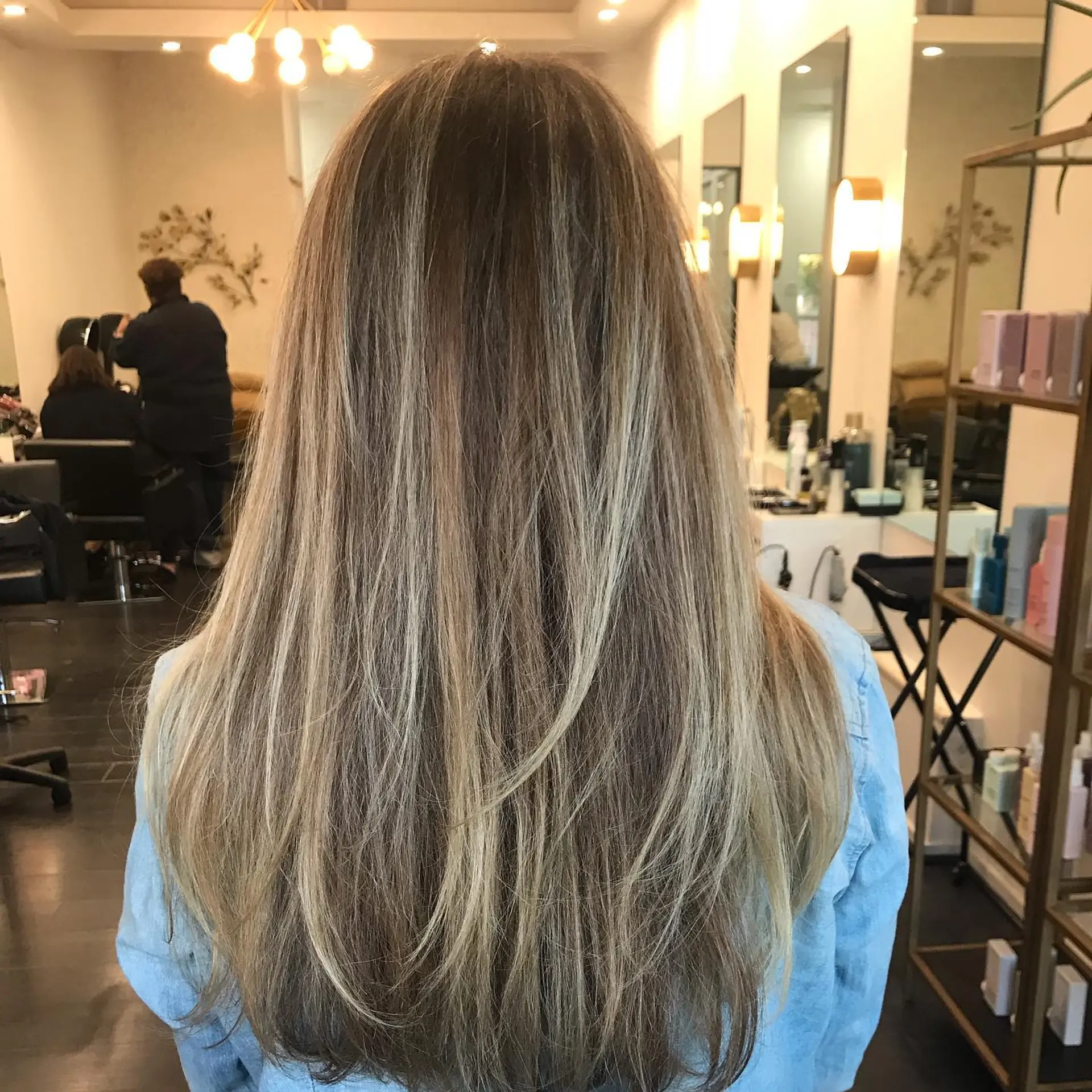Long hair featuring finely blended multi-tonal blonde highlights over a neutral brown base with light layering. 1