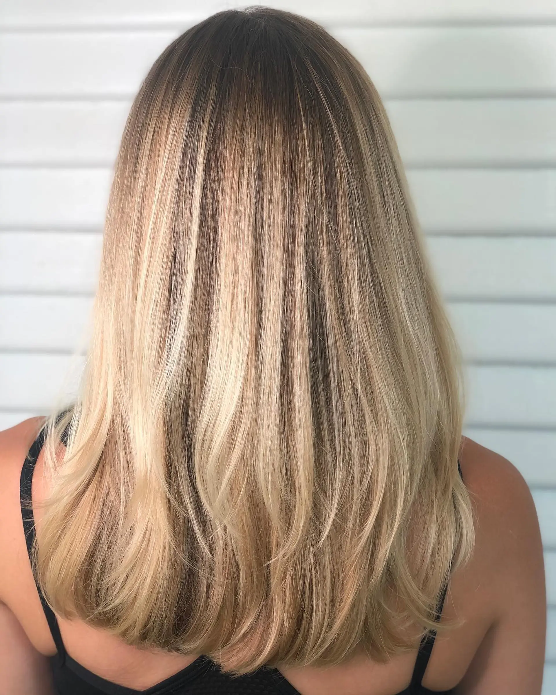 Long hair featuring a seamless golden blonde balayage with subtle layering and smooth, curved ends. 1