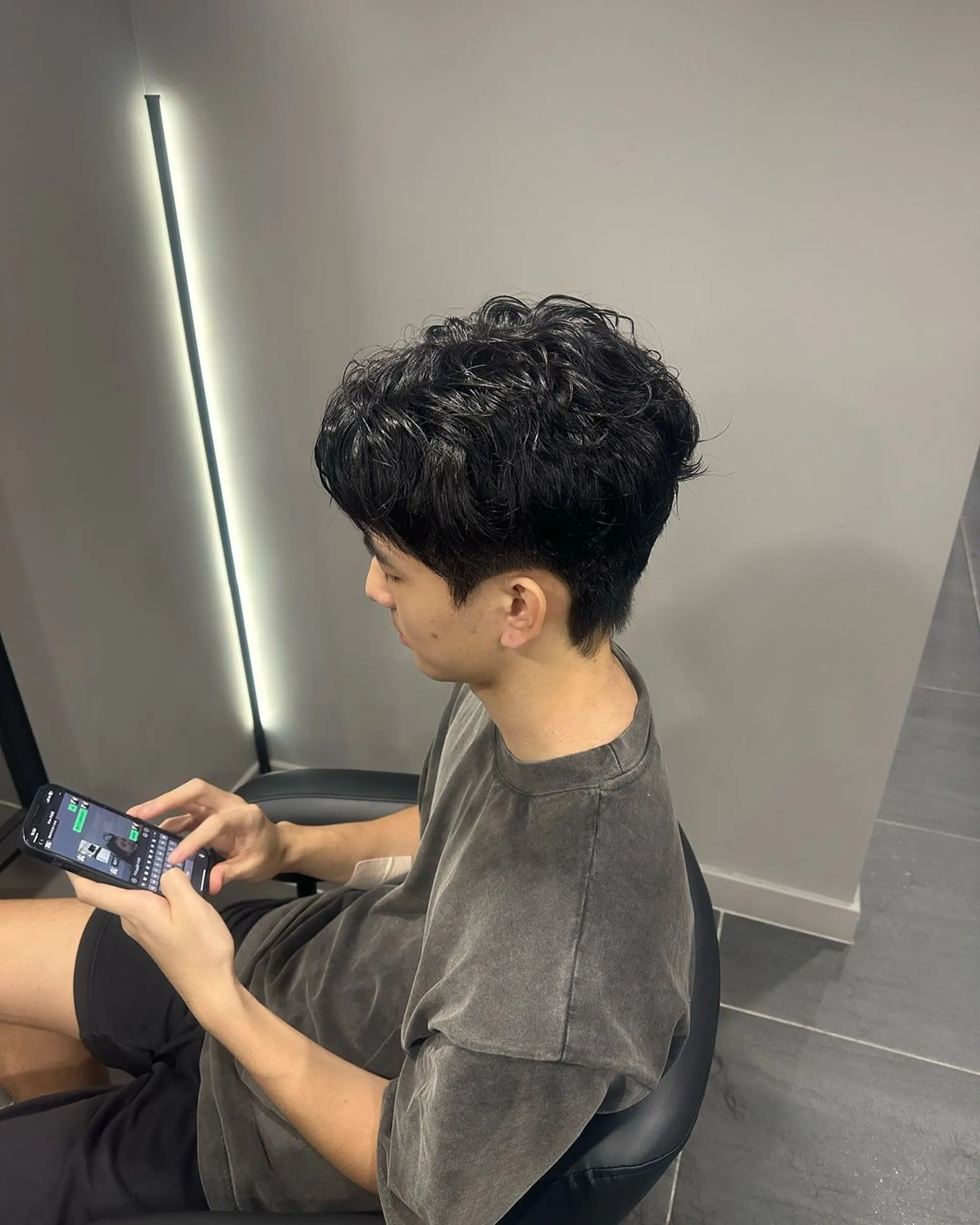 A short, wavy, tousled hairstyle with a textured, casual appearance. The black hair is styled in a laid-back fashion, giving a chic and relaxed vibe. 2