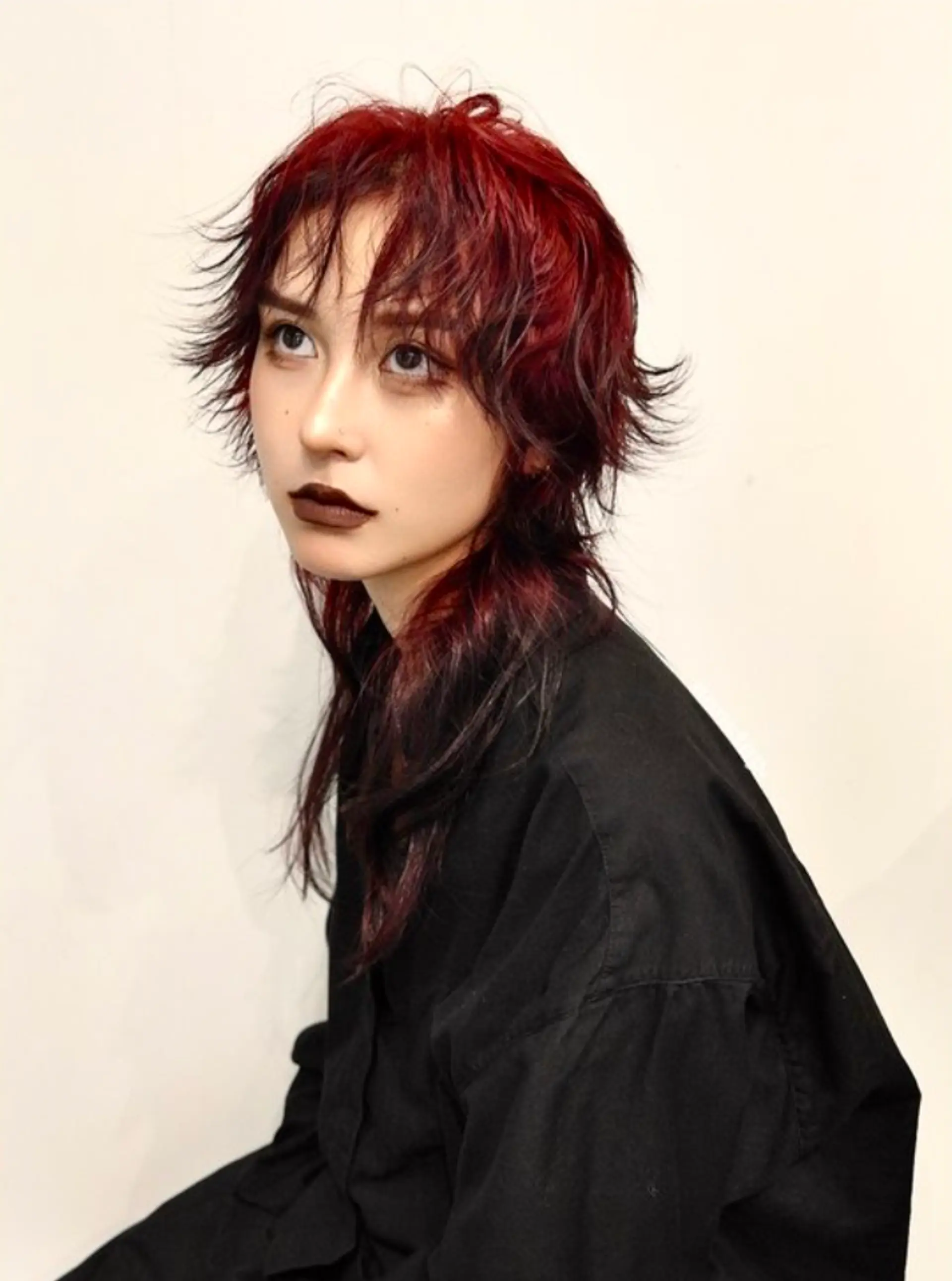 Medium-length wavy hair in crimson red and black, styled in a modern mullet with choppy, textured layers and bold, choppy bangs.

(NonstopStyle: by Kelvin & Vincent) 1