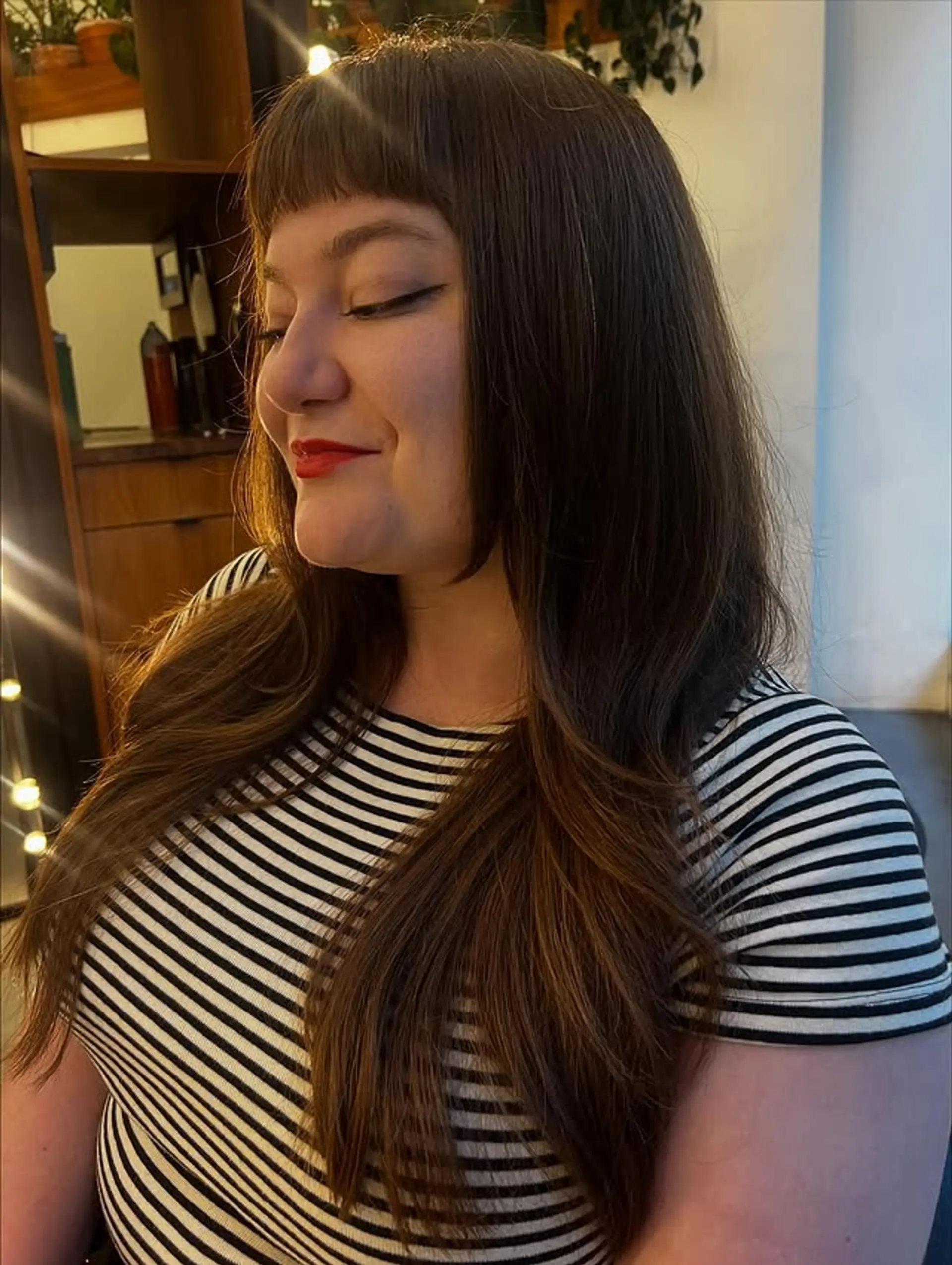 A long layered hairstyle with modern curtain bangs that frame the face beautifully. 1