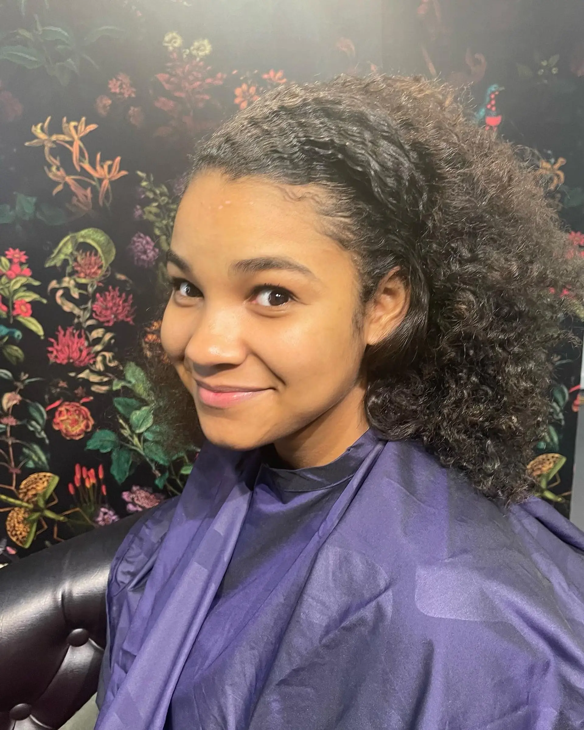 Shoulder-length textured curls swept back smoothly from the hairline into voluminous curls enhanced with subtle golden highlights. 1