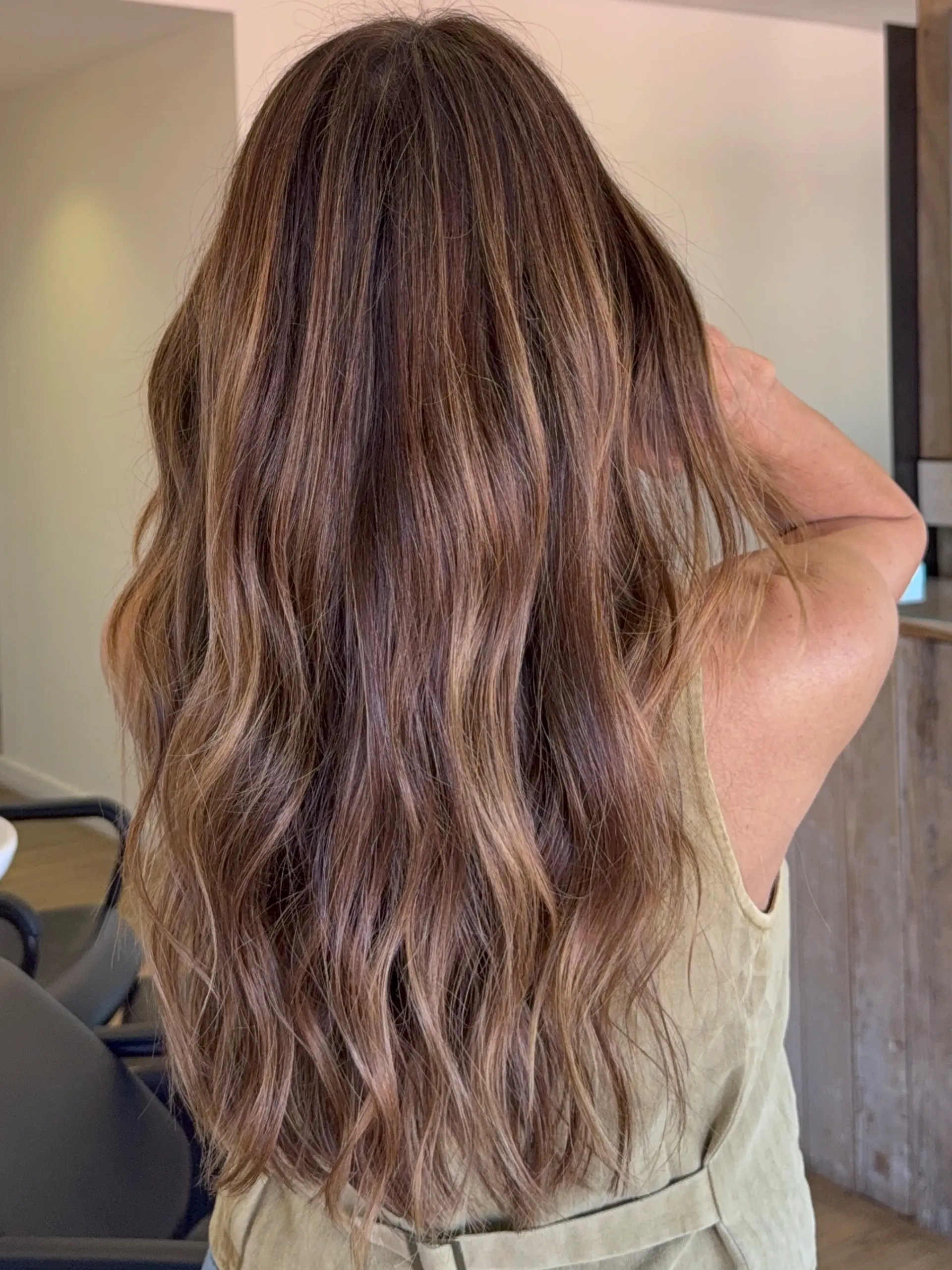Long wavy brunette hair featuring seamless caramel and honey blonde balayage highlights. 1
