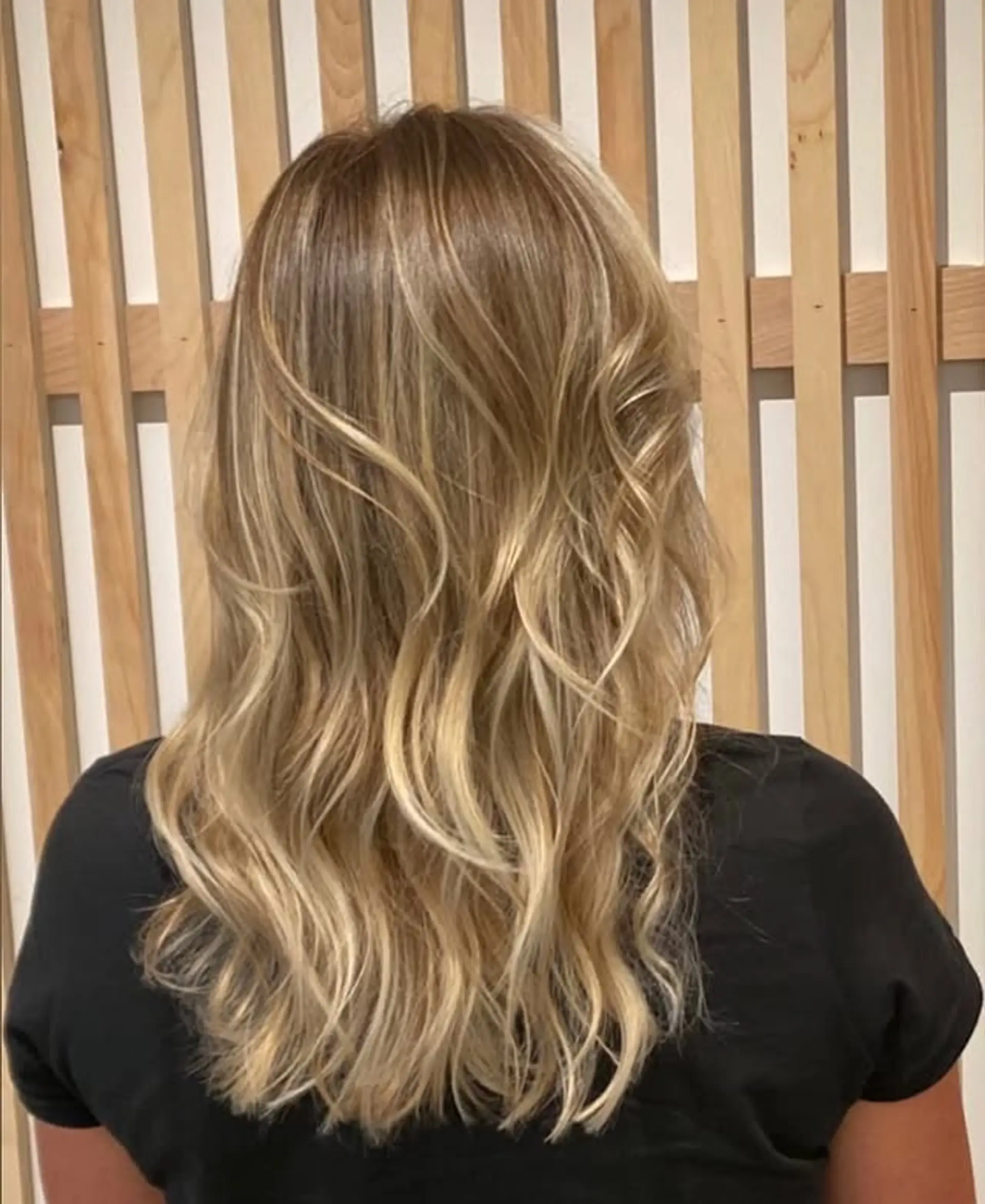 A layered medium-length wavy hairstyle with a bronde balayage. 1