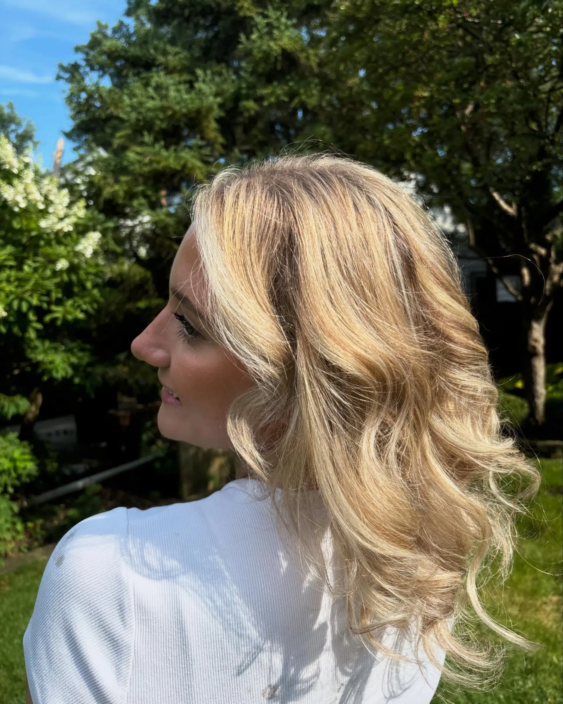 Medium-length dimensional blonde hair with multi-tonal highlights, styled in soft voluminous waves. 1