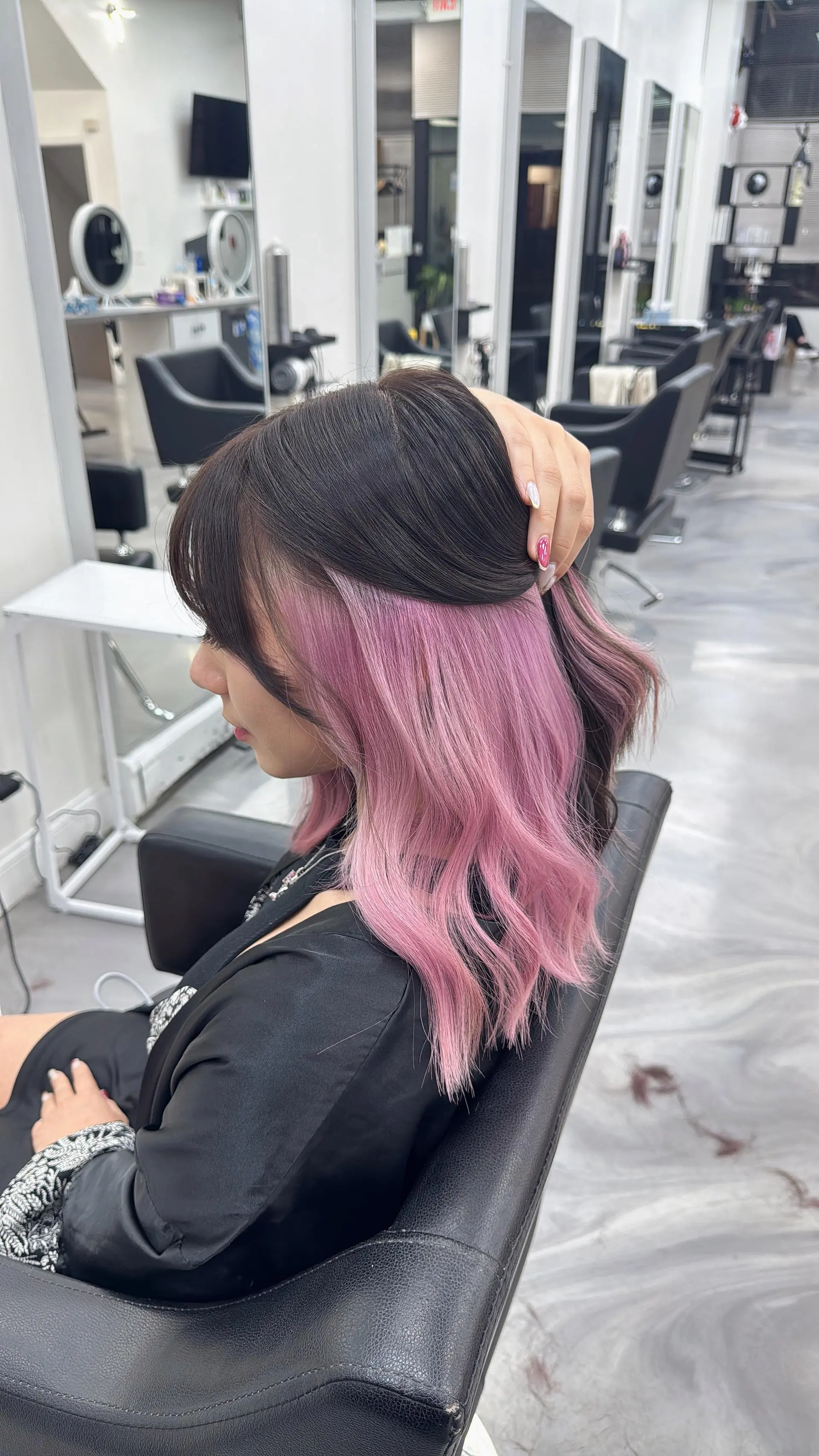 Shoulder-length dark hair featuring a vibrant pastel pink under-dye peekaboo color with soft waves. 1