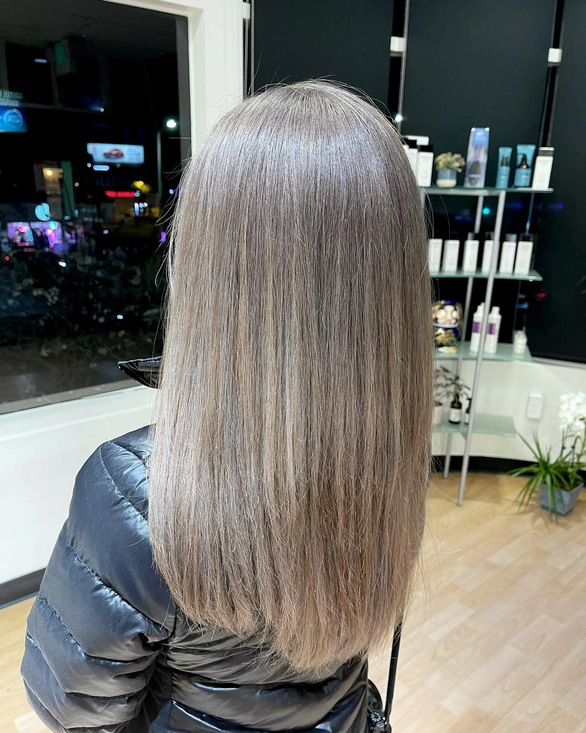 Long, sleek straight hair finished in a cool ash silver-blonde tone with seamless multidimensional coverage. 1