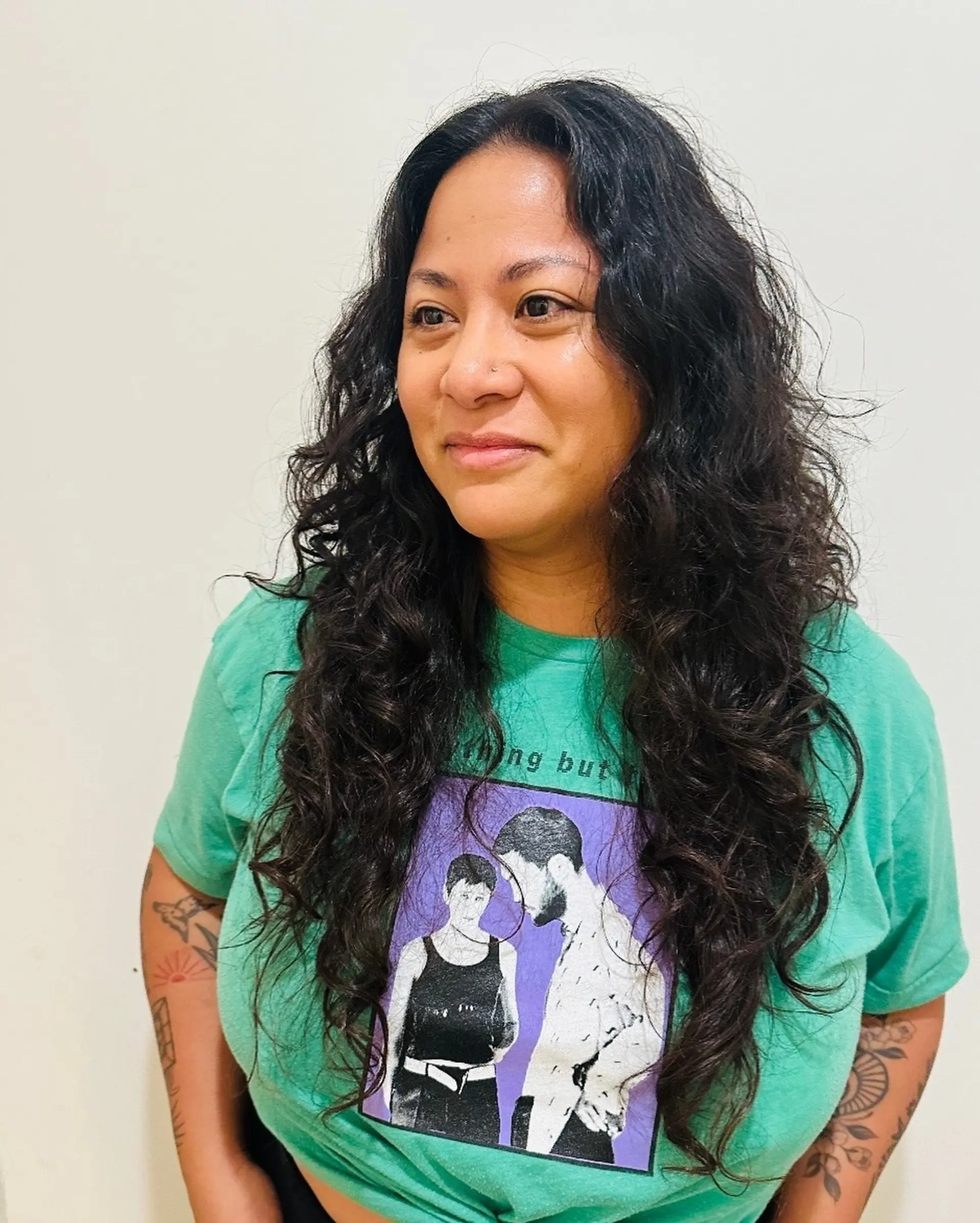 Long, naturally textured curly haircut featuring cascading layers and soft face-framing definition. 1