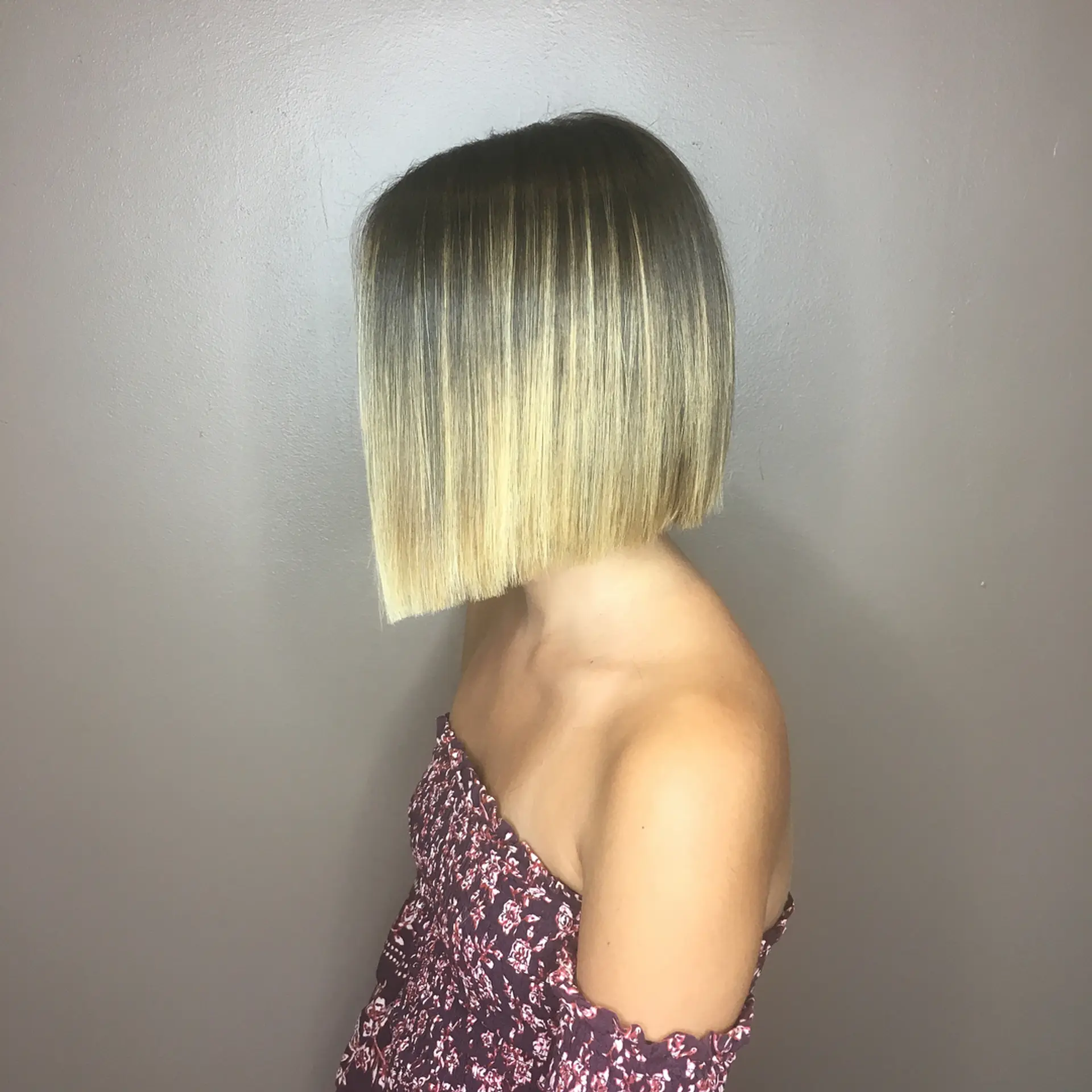 A sleek, precision-cut blunt bob with dark roots softly blending into bright golden blonde tones. 1