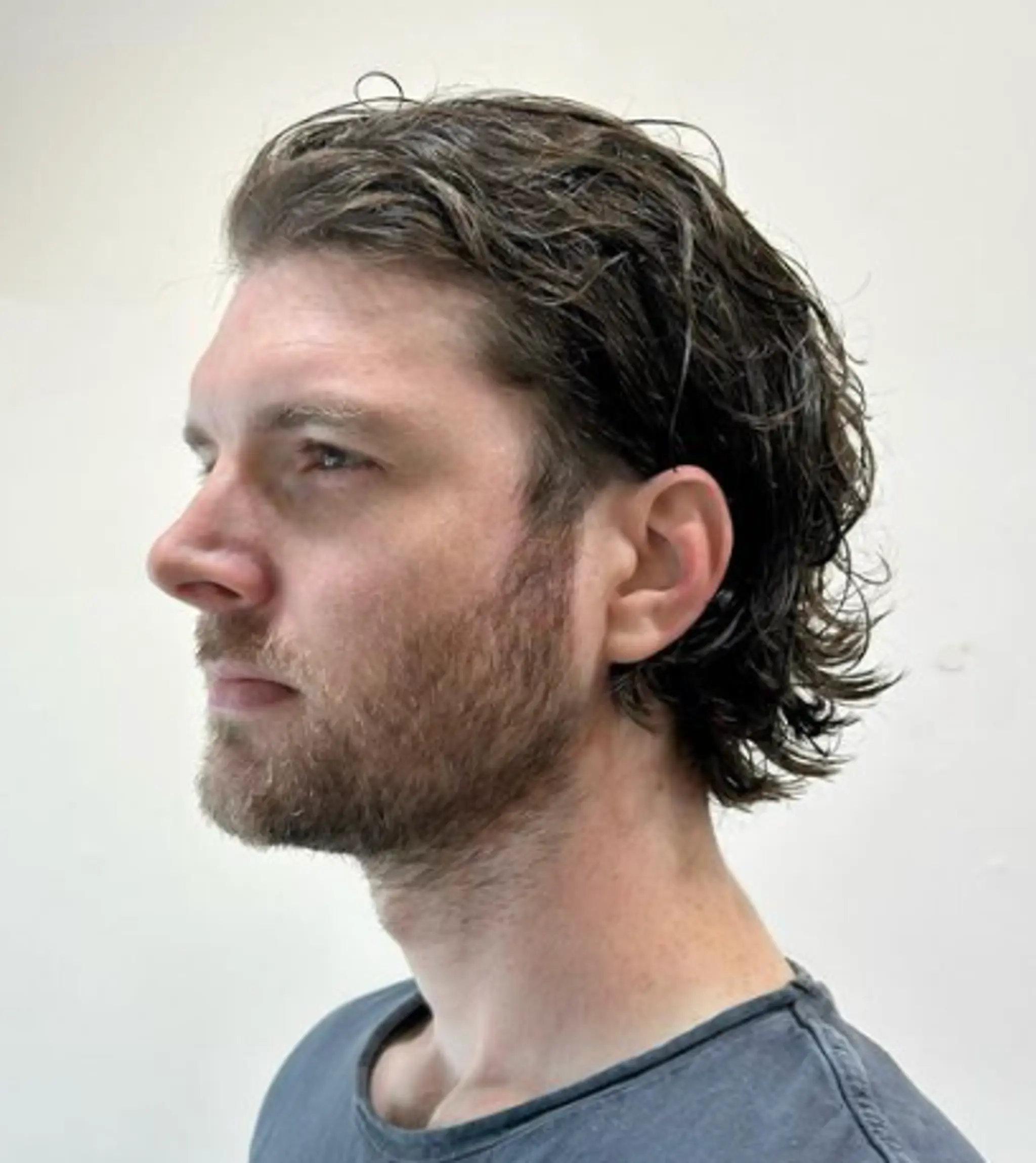Medium-length, wavy brown hair with side-swept waves and natural volume, styled casually to create a relaxed and effortless look.