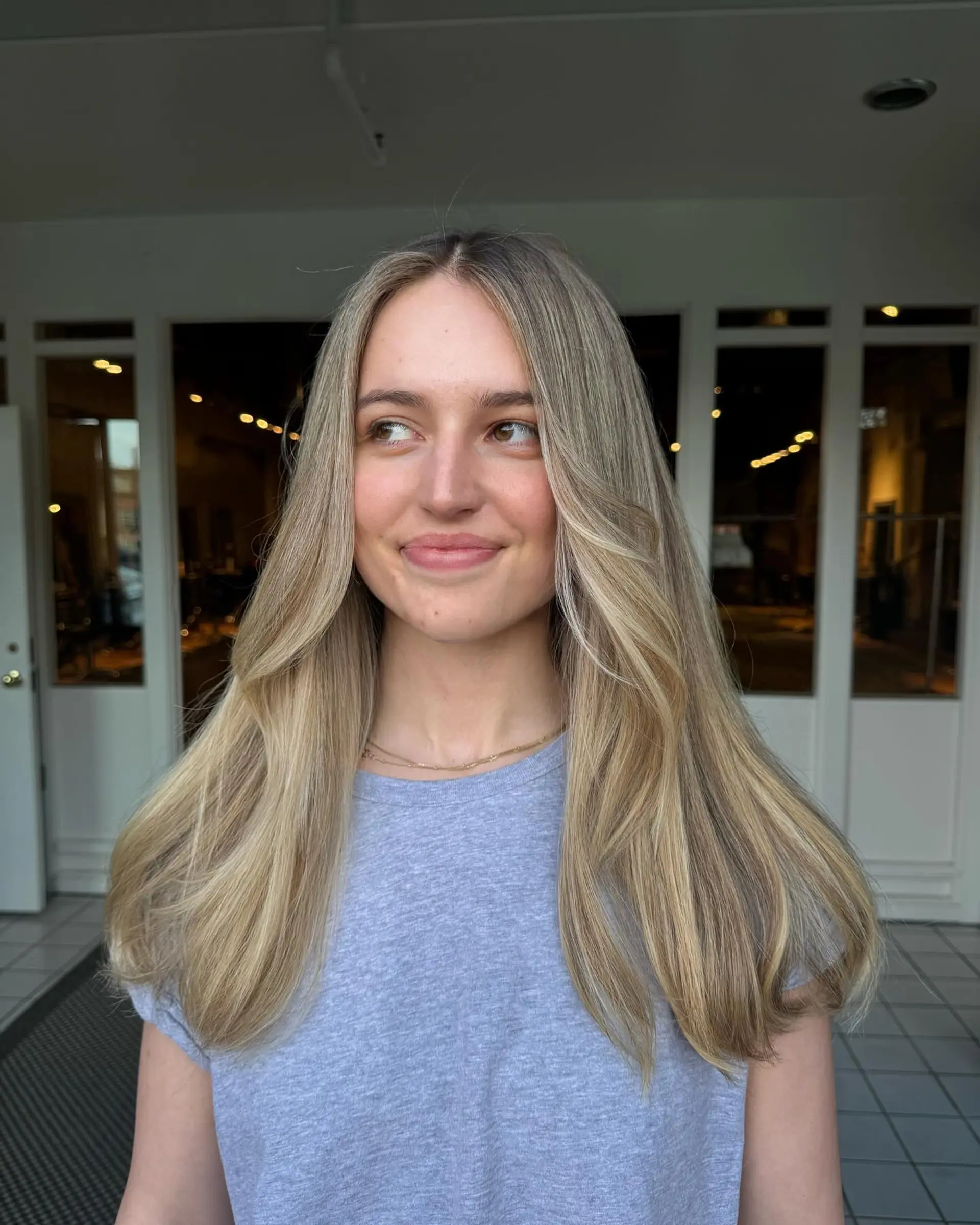 Long beige blonde balayage with middle part and soft face-framing layers. 1